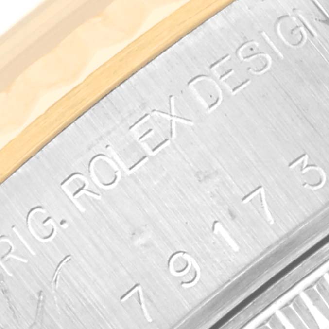 Close-up angle showing the engraved serial and model numbers on the metal case of the Rolex Datejust 79173 Women's Steel and Gold (two tone) Silver Dial 79173 Women's Steel and Gold (two tone) Silver Dial.