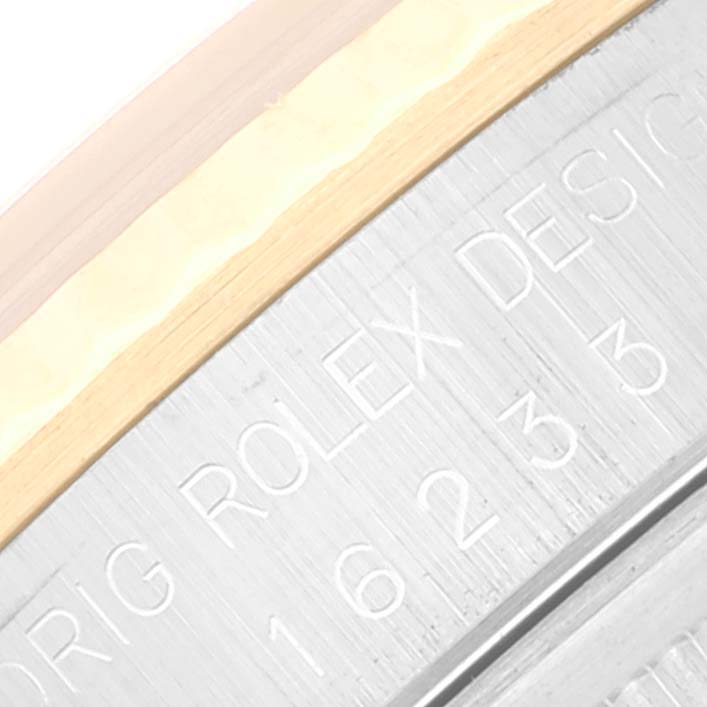 The image shows a close-up of the Datejust model by Rolex, focusing on the detailed engraving on the side of the bezel.