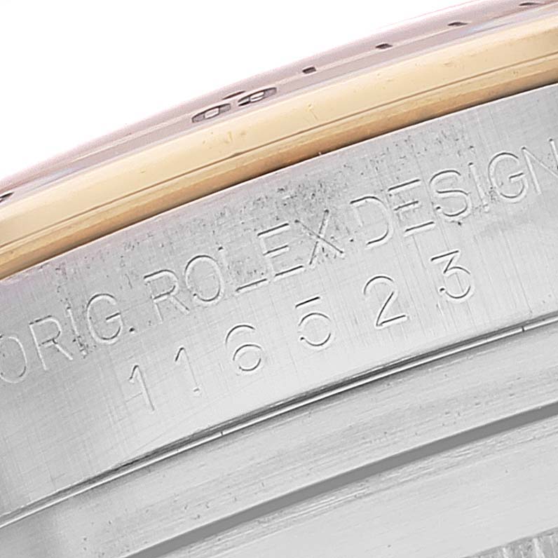 This close-up image shows the engraved design number on the side of a Rolex Daytona 116523 Men's Steel and Gold (two tone) Mother of Pearl Dial 116523 Men's Steel and Gold (two tone) Mother of Pearl Dial watch.