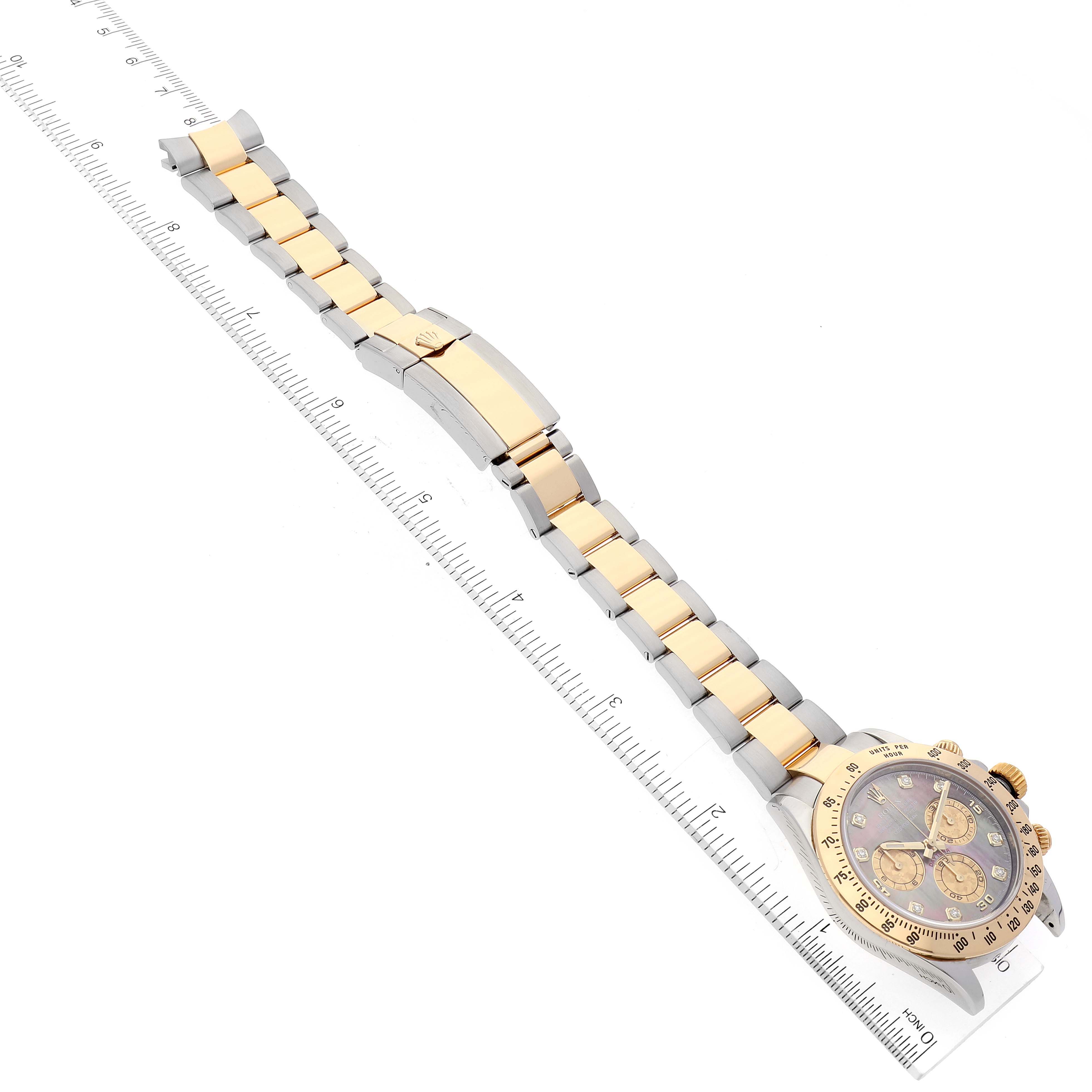 The image shows a Rolex Daytona 116523 Men's Steel and Gold (two tone) Mother of Pearl Dial 116523 Men's Steel and Gold (two tone) Mother of Pearl Dial watch laying flat, highlighting its dial and bracelet, measured with a ruler.