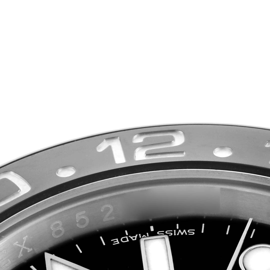 The image shows the top portion of the bezel and dial of a Rolex GMT-Master 116710 Men
s Stainless Steel Black Dial watch, highlighting the "12" numeral and markers.