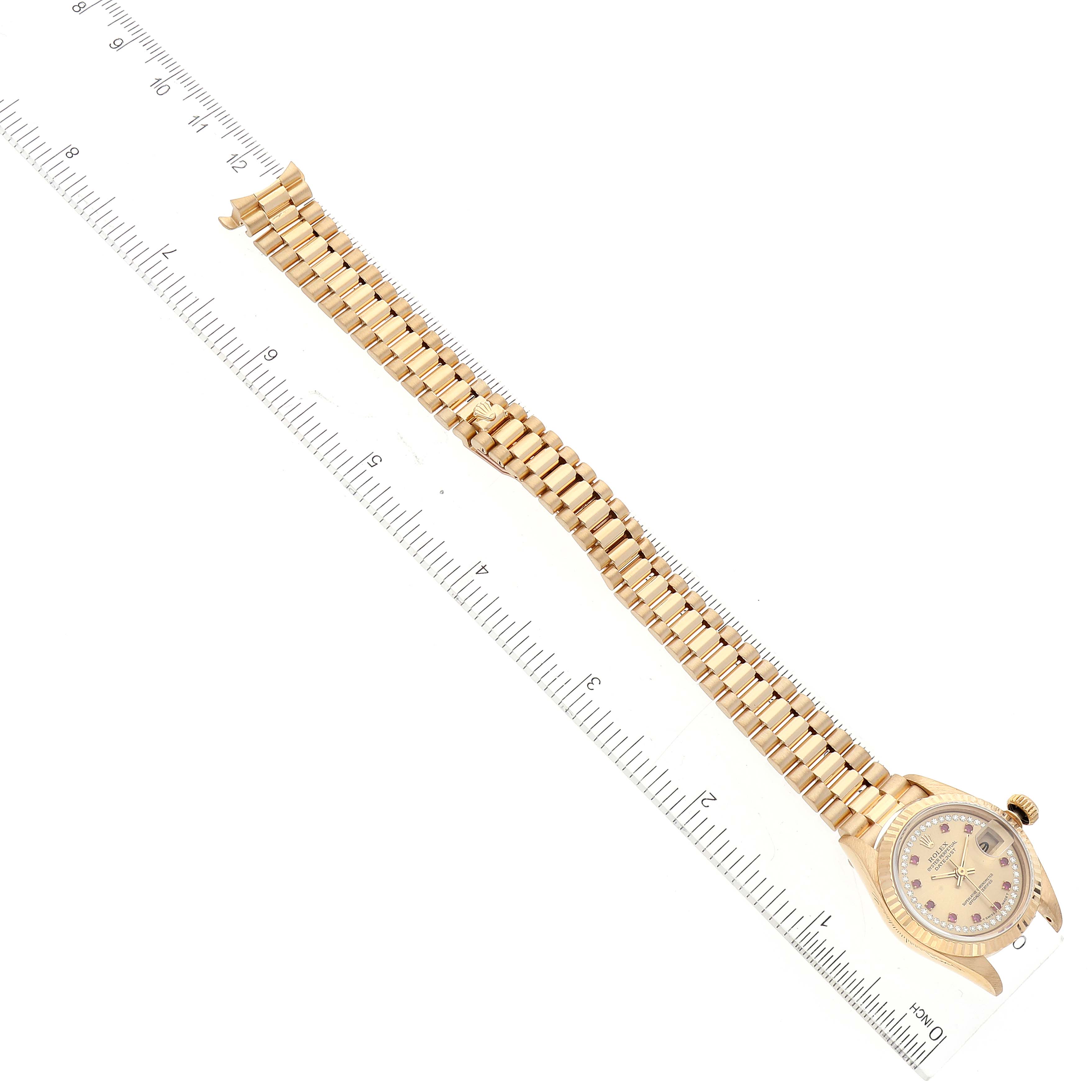 This image shows a Rolex President 69178 Women's Yellow Gold Champagne Dial 69178 Women's Yellow Gold Champagne Dial model watch laid flat with the face and entire bracelet visible alongside a ruler for size reference.