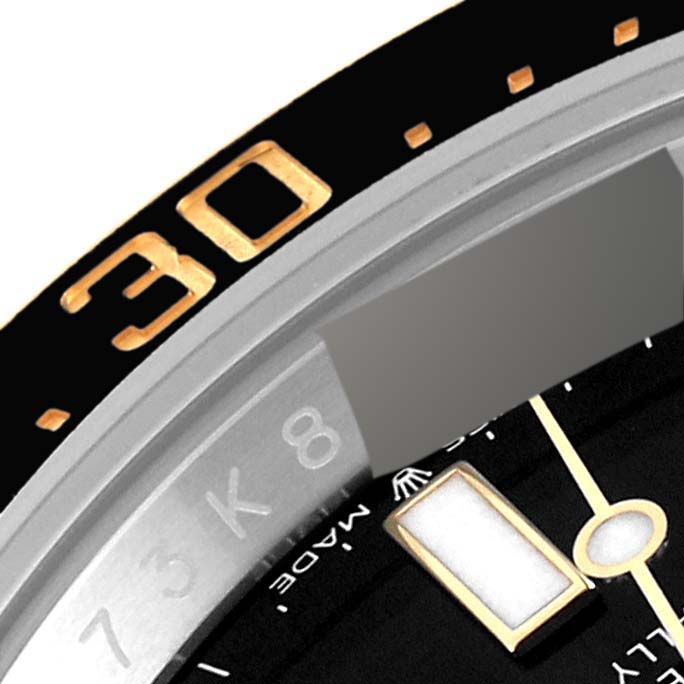 This close-up of a Rolex Sea-Dweller 126603 Men's Steel and Gold (two tone) Black Dial 126603 Men's Steel and Gold (two tone) Black Dial watch shows part of the bezel and dial, including the '30' minute marker and hour index.