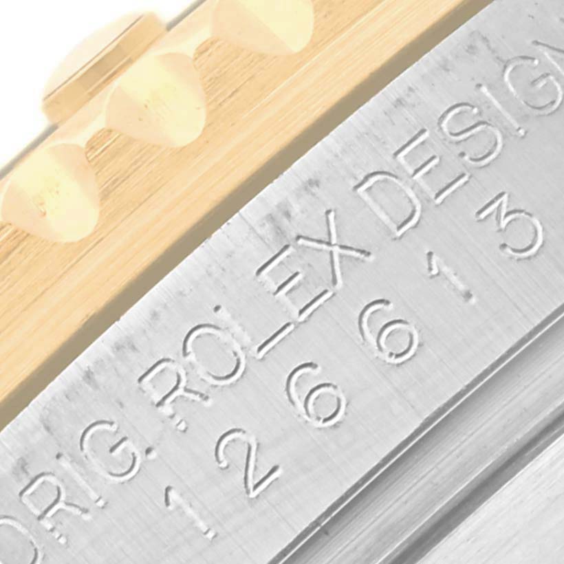 The image shows a close-up of the edge and part of the bezel of a Rolex Submariner 126613LB Men's Steel and Gold (two tone) Blue Dial 126613LB Men's Steel and Gold (two tone) Blue Dial watch.