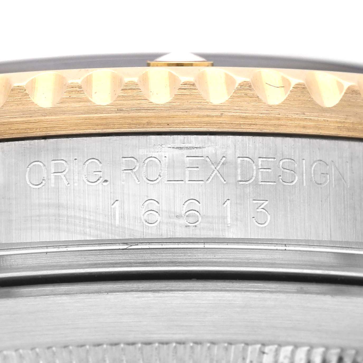 This image shows a close-up of the side of a Rolex Submariner 16613 Men's Steel and Gold (two tone) Black Dial 16613 Men's Steel and Gold (two tone) Black Dial watch, focusing on the engraved model number and "Orig. Rolex Design."