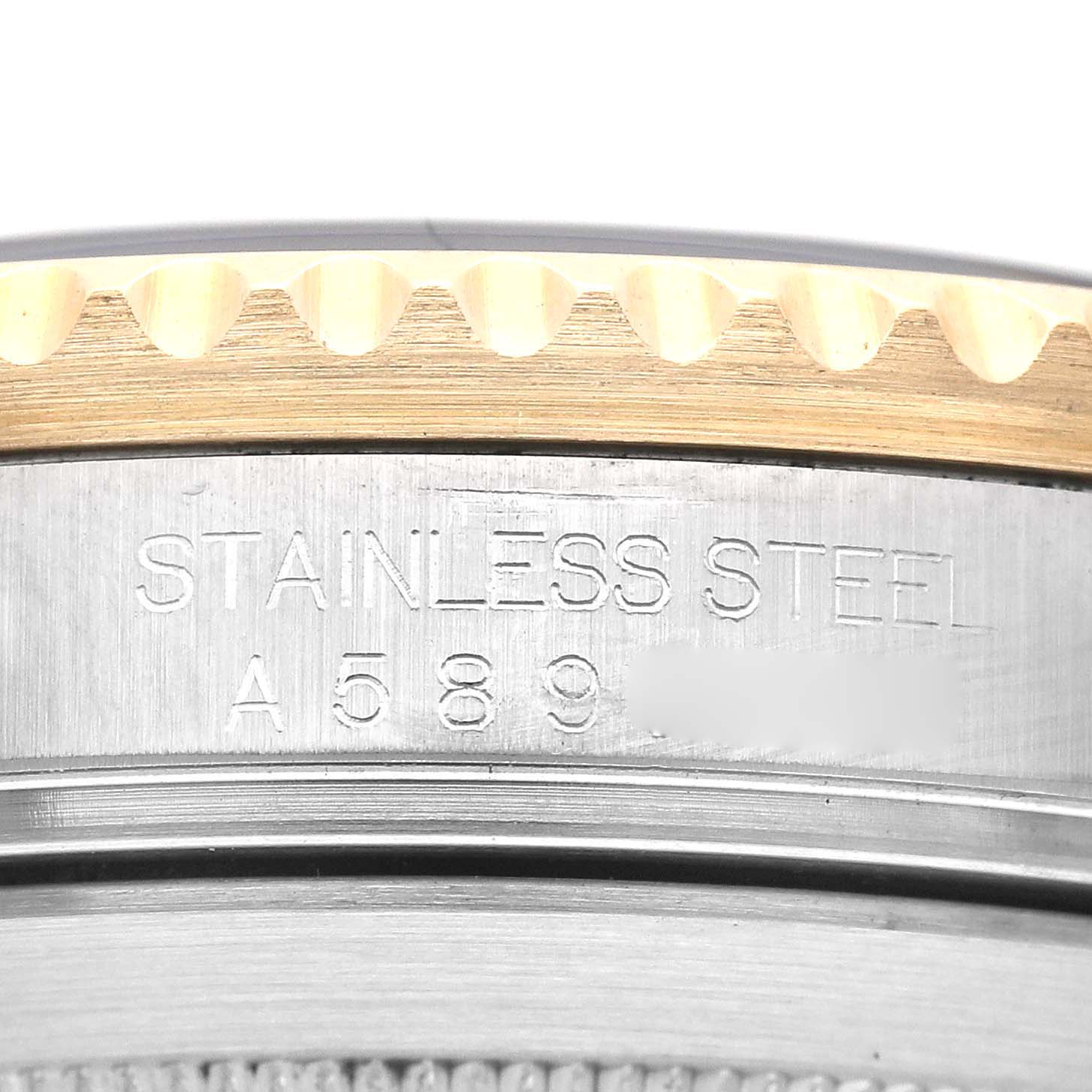 This close-up image of the Rolex Submariner 16613 Men's Steel and Gold (two tone) Black Dial 16613 Men's Steel and Gold (two tone) Black Dial shows the engraved serial number and stainless steel case back, partially revealing the bezel.