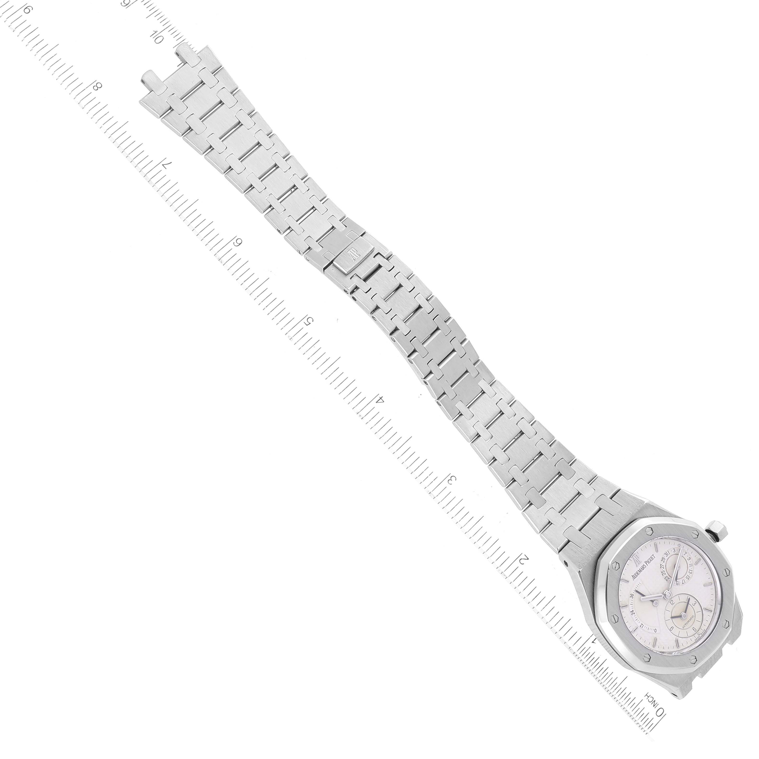 The image shows a top-down view of a Royal Oak watch by Audemars Piguet, highlighting the watch face and full metal bracelet against a ruler for scale.