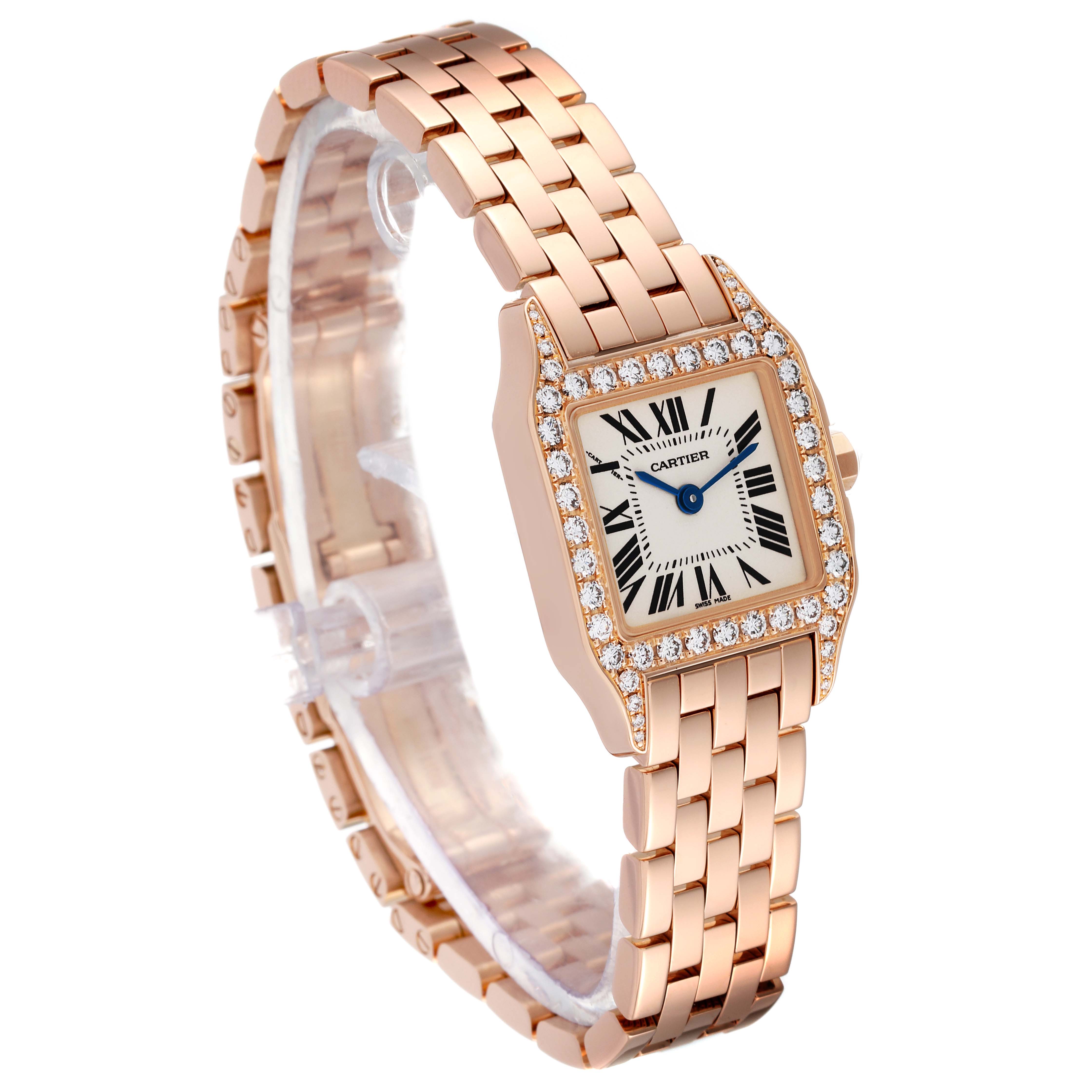 The Cartier Santos Demoiselle WF9011Z8 Women's Rose Gold Silver Dial WF9011Z8 Women's Rose Gold Silver Dial watch is shown at an angle, displaying its face, bracelet, and bezel adorned with diamonds.