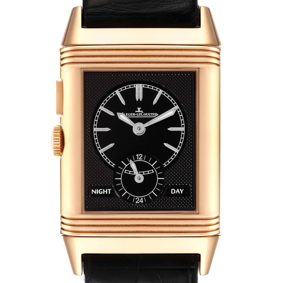 The image shows a front view of the Jaeger-LeCoultre Reverso watch, highlighting its black dial, gold case, and day-night indicator.