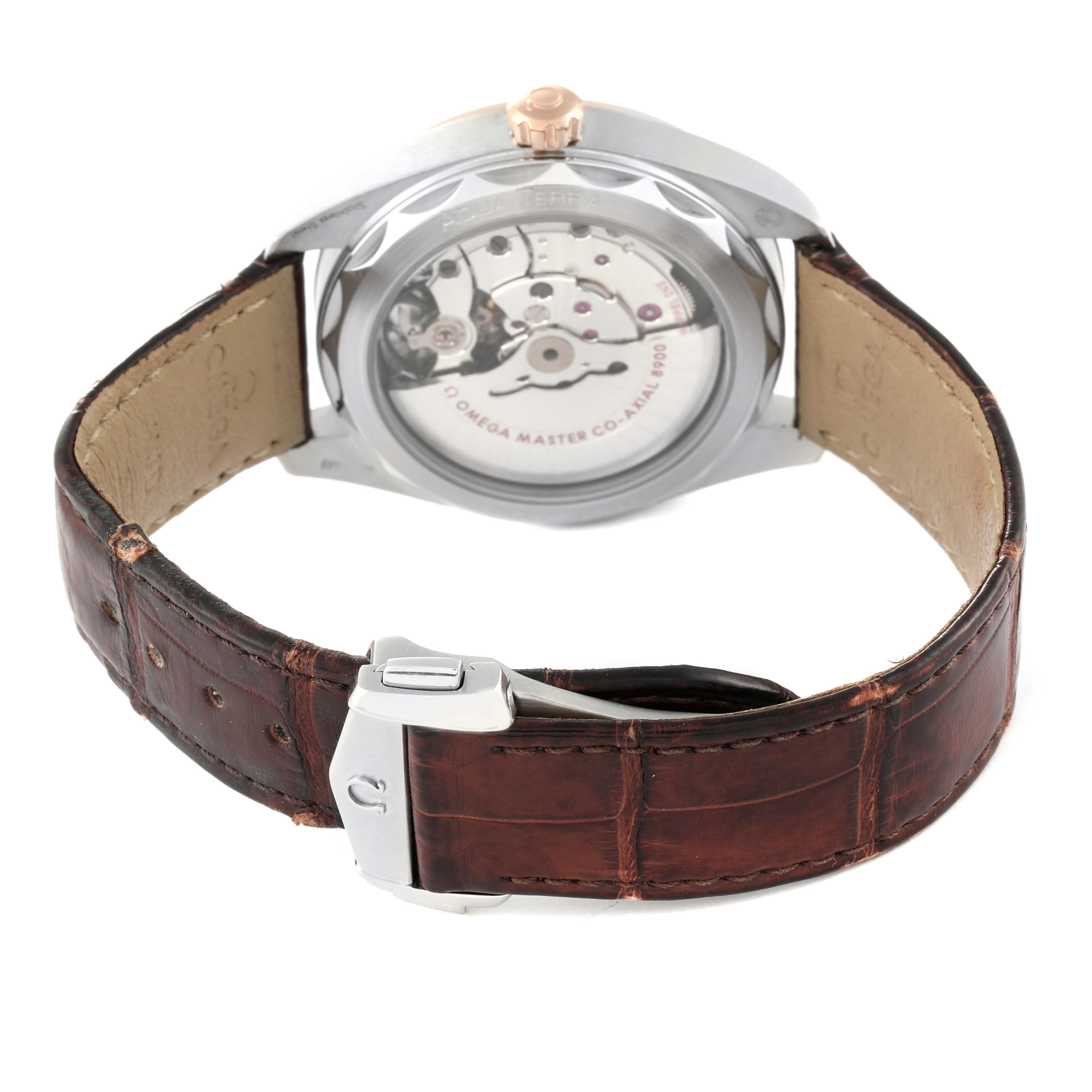 The image shows the back view of an Omega Aqua Terra 220.23.41.21.02.001 Men's Steel and Gold (two tone) Silver Dial 220.23.41.21.02.001 Men's Steel and Gold (two tone) Silver Dial watch, highlighting the movement with an open case back and brown leather strap.