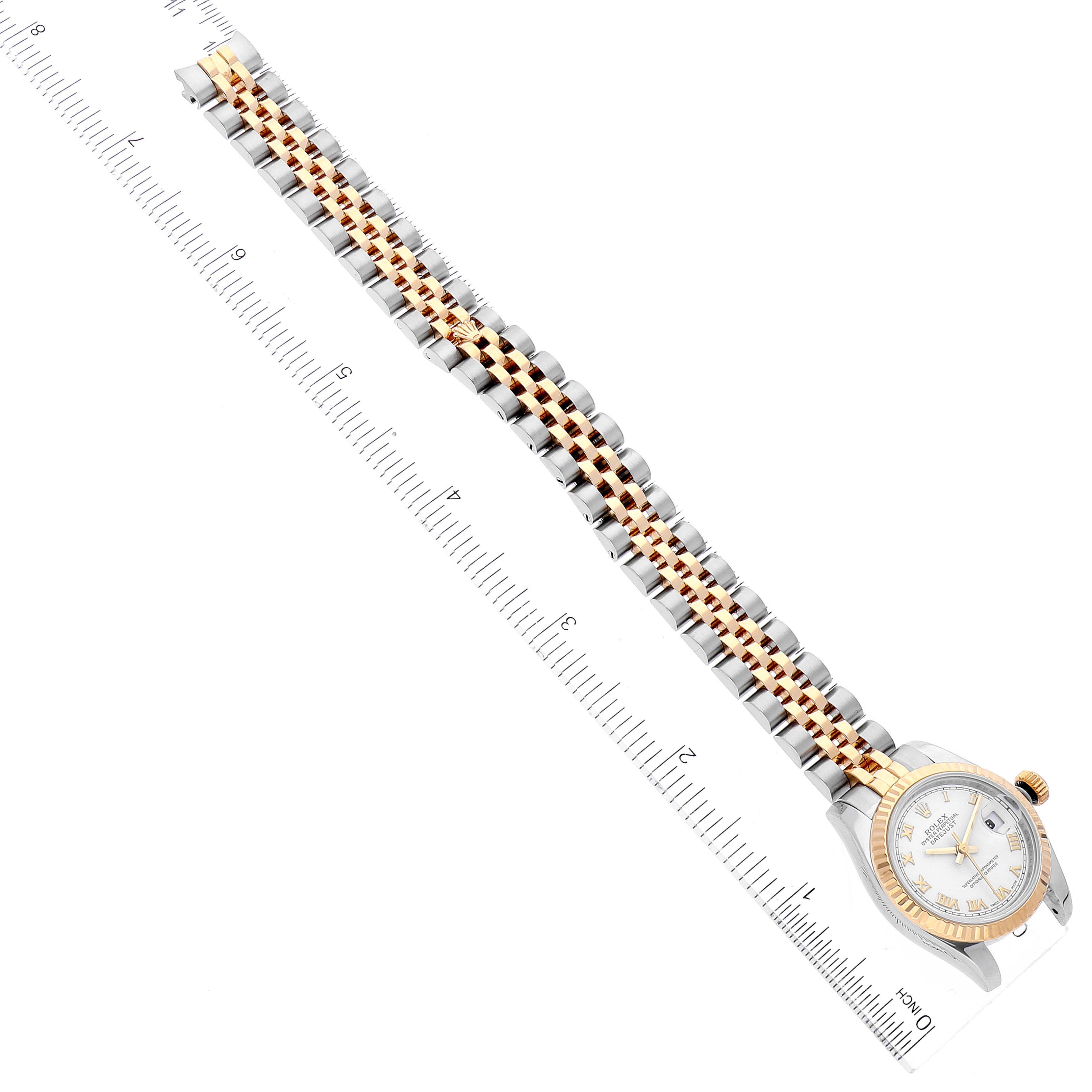 The image shows a Rolex Datejust 179173 Women's Steel and Gold (two tone) White Dial 179173 Women's Steel and Gold (two tone) White Dial watch laid flat against a measuring ruler, displaying its full band and face.