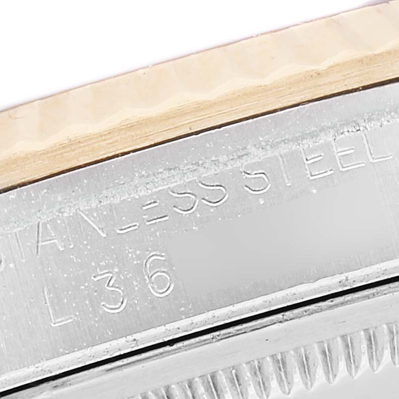 The image shows a close-up of the side of the stainless steel bezel and case of a Rolex Datejust 16233 Men's Steel and Gold (two tone) Blue Dial 16233 Men's Steel and Gold (two tone) Blue Dial watch.