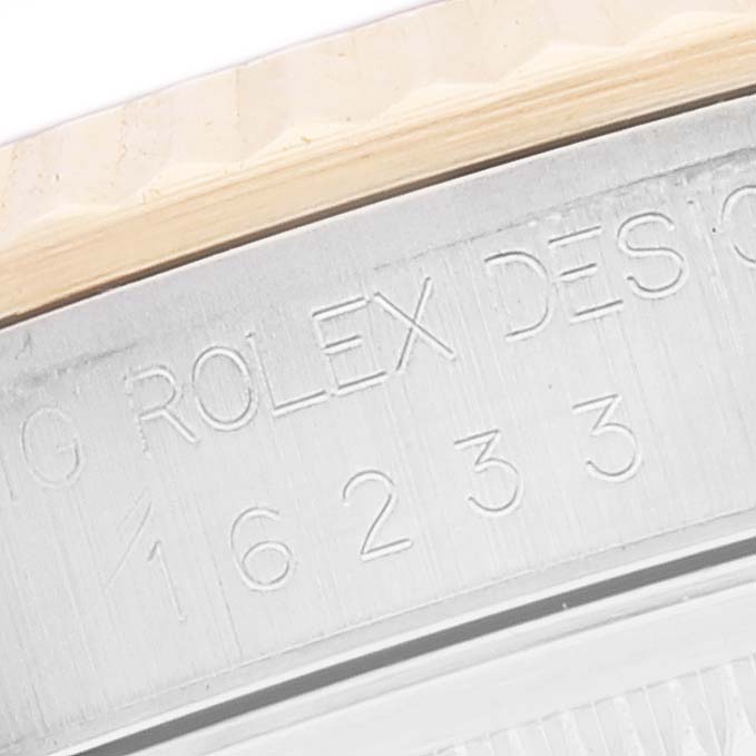 This close-up image shows the model number and branding engraved on the case of a Rolex Datejust 16233 Men's Steel and Gold (two tone) Black Dial 16233 Men's Steel and Gold (two tone) Black Dial watch.