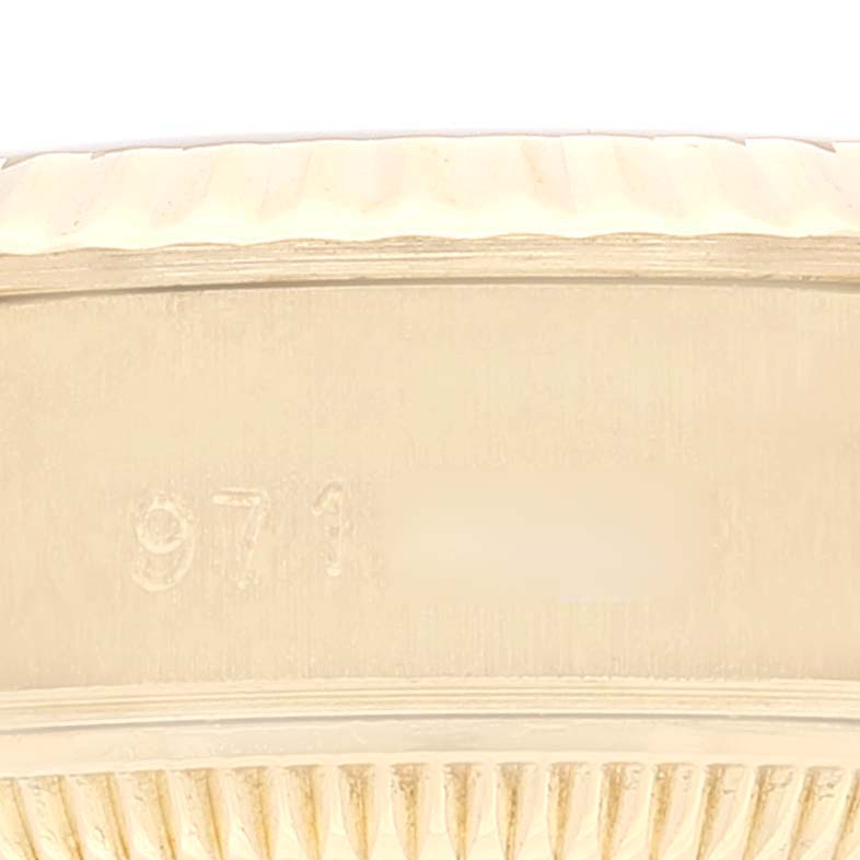 The image shows a close-up of the side of a President model by Rolex, highlighting the fluted bezel and part of the engraved serial number.