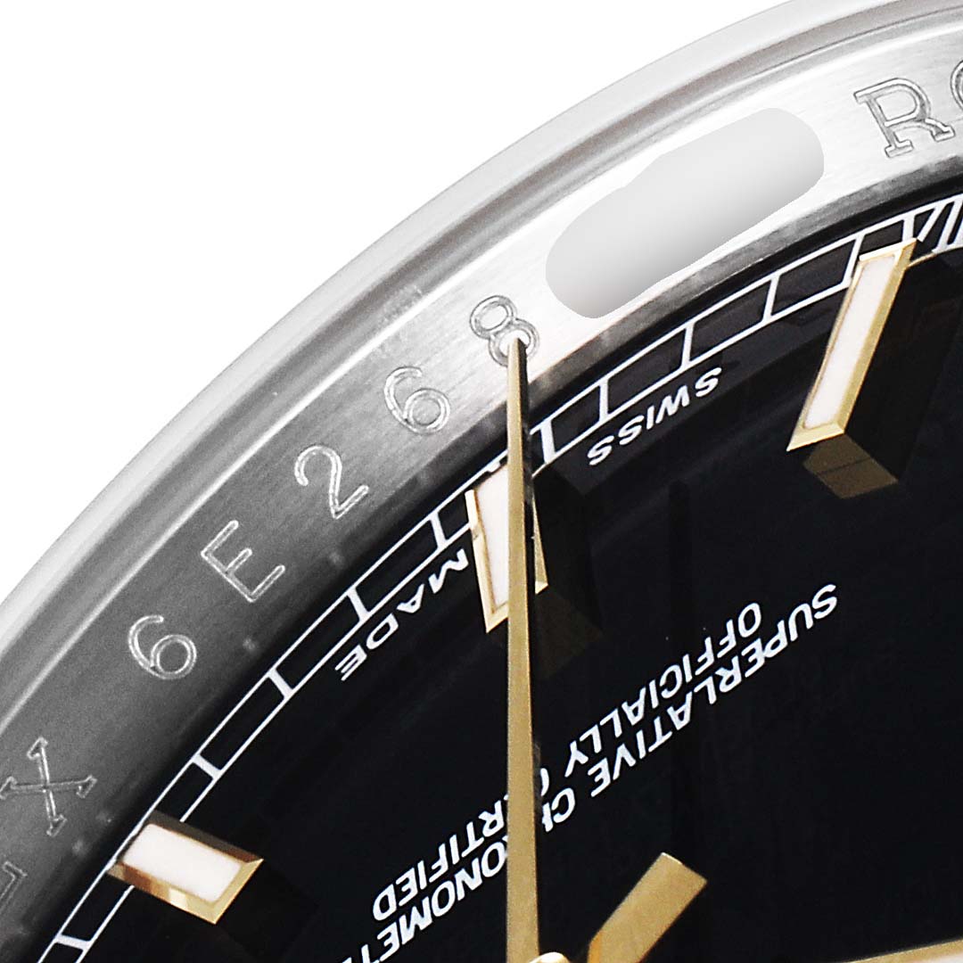 This close-up image of the Rolex Datejust 116233 Men's Steel and Gold (two tone) Black Dial 116233 Men's Steel and Gold (two tone) Black Dial watch shows a part of the dial, the minute hand, and the rehaut with engraved serial numbers.