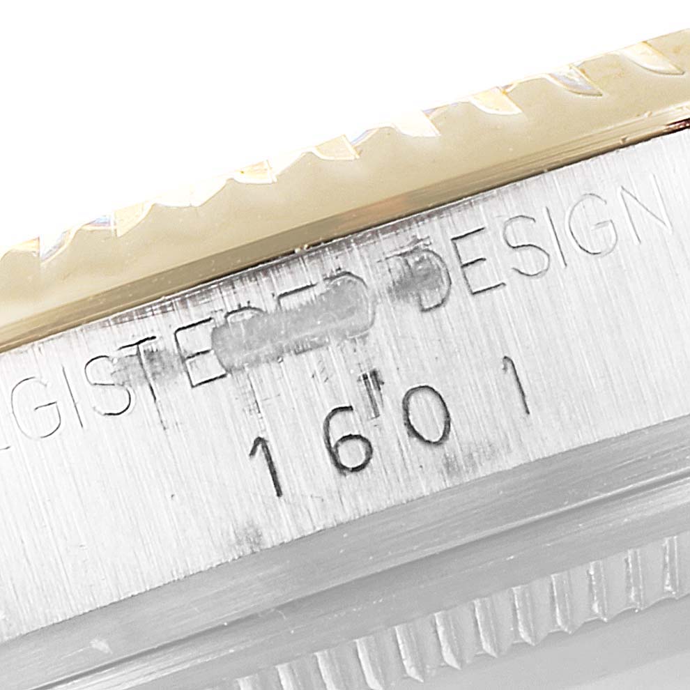 This image shows a close-up of the model number "1601" and part of the bezel of a Rolex Vintage Collection 1601 Men's Steel and Gold (two tone) Blue Dial 1601 Men's Steel and Gold (two tone) Blue Dial watch.