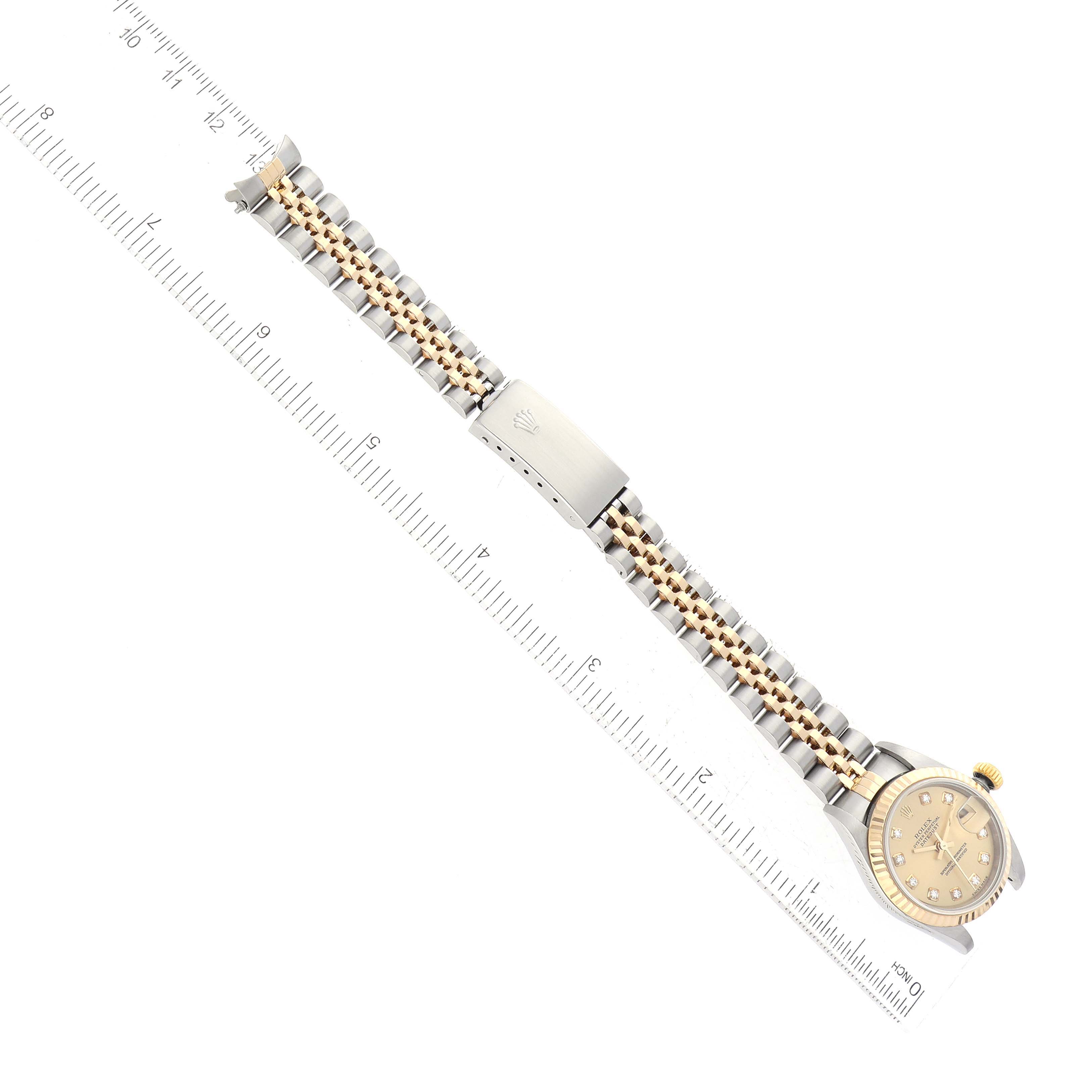 The image shows a Rolex Datejust 79173 Women's Steel and Gold (two tone) Champagne Dial 79173 Women's Steel and Gold (two tone) Champagne Dial watch in a top-down angle, displaying its bezel, dial, and Jubilee bracelet with a ruler.