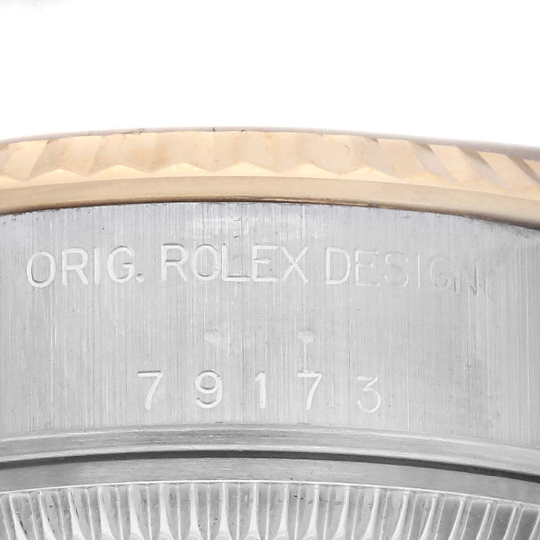 The image shows a close-up of the side of a Rolex Datejust 79173 Women's Steel and Gold (two tone) Champagne Dial 79173 Women's Steel and Gold (two tone) Champagne Dial, featuring engraved text "ORIG. ROLEX DESIGN" and model number 79173.