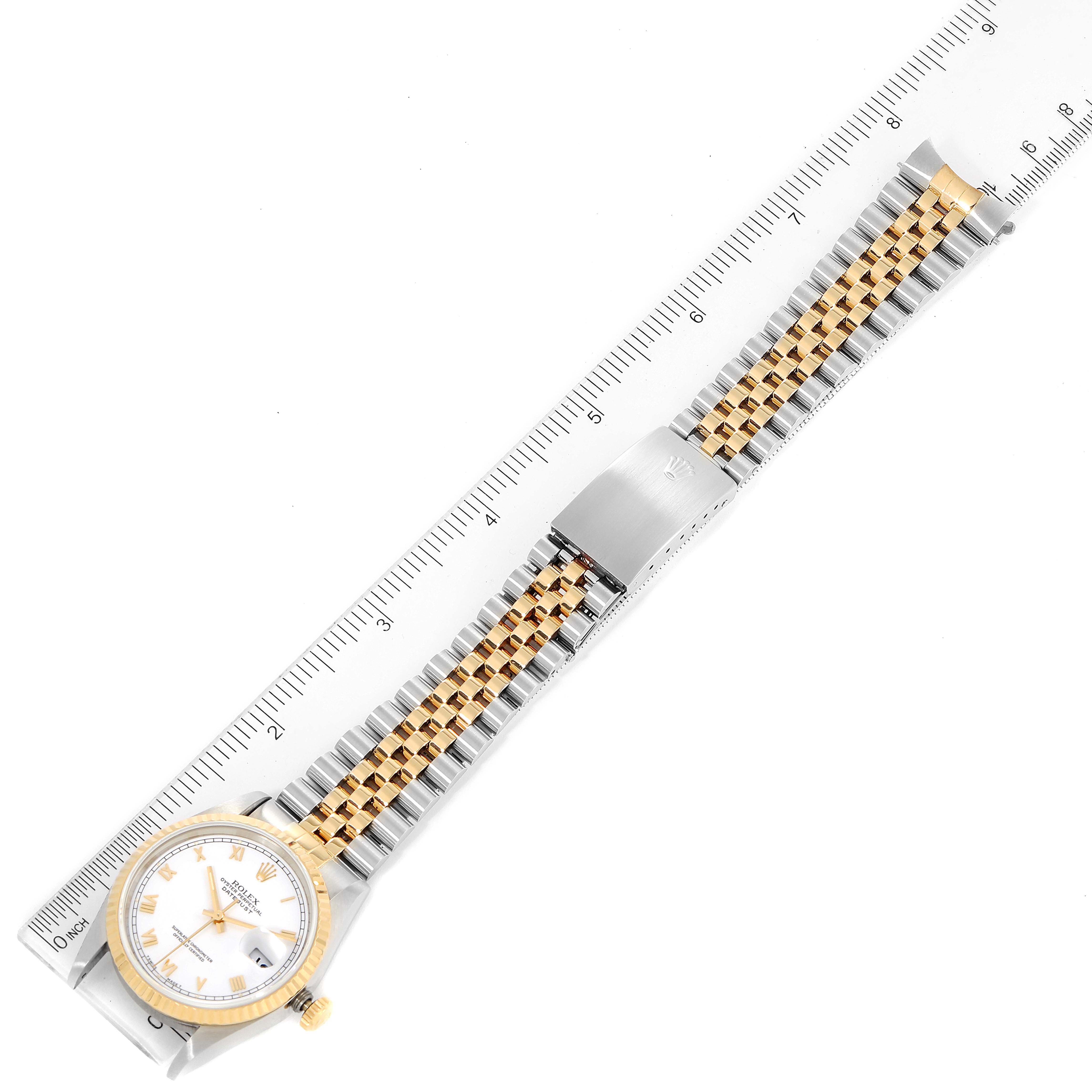The image shows a Rolex Datejust 16233 Men's Steel and Gold (two tone) White Dial 16233 Men's Steel and Gold (two tone) White Dial watch laid flat with a ruler beside it, displaying the face and two-tone bracelet.