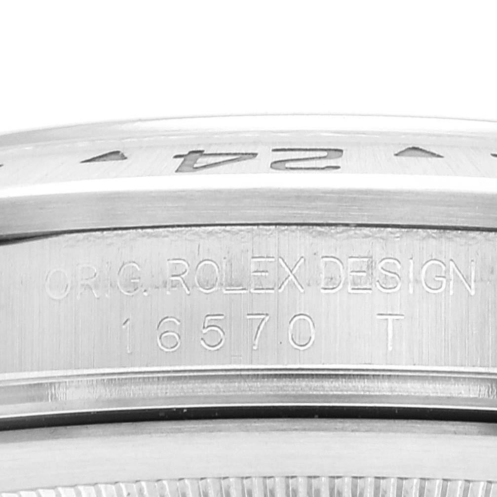 The image shows a close-up of the side of a Rolex Explorer 16570 Men's Stainless Steel White Dial 16570 Men's Stainless Steel White Dial model watch, focusing on the engraved model number and design text.