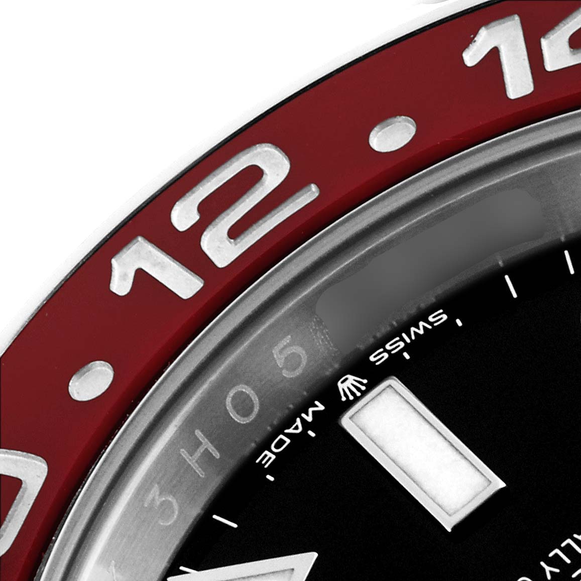 This close-up image of the Rolex GMT-Master 126710 Men
s Stainless Steel Black Dial 126710 Men
s Stainless Steel Black Dial watch shows the bezel with the number "12" and part of the dial with the "Swiss Made" text.