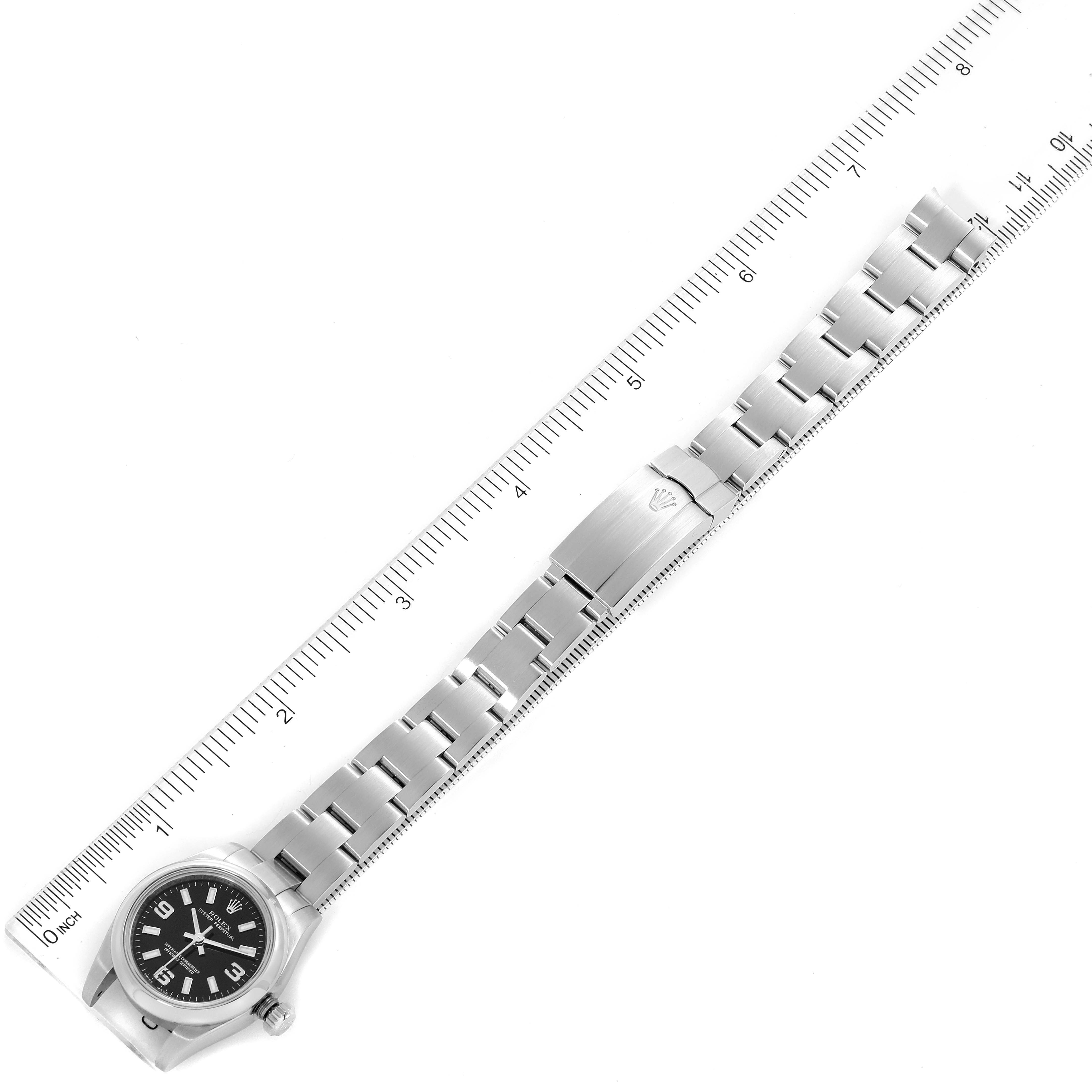 The image shows a top-down view of the entire Rolex Oyster Perpetual 176200 Women's Stainless Steel Black Dial 176200 Women's Stainless Steel Black Dial watch, including the face, bezel, and bracelet with a ruler for scale.