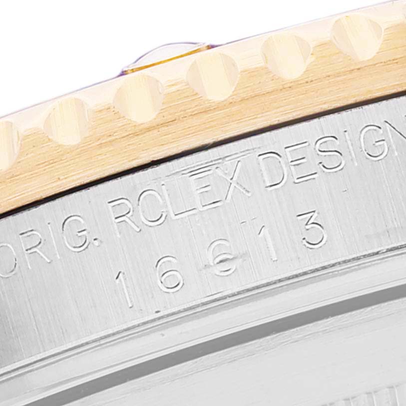 This close-up image shows the engraved model number and part of the bezel of a Rolex Submariner 16613 Men
s Steel and Gold (two tone) Champagne Dial 16613 Men
s Steel and Gold (two tone) Champagne Dial watch.