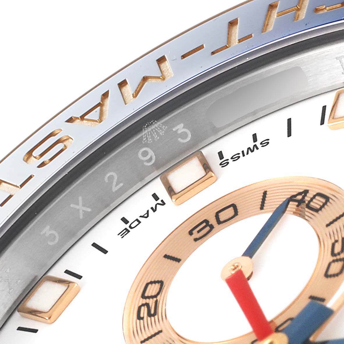 This close-up of the Rolex Yacht-Master 116681 Men's Steel and Gold (two tone) White Dial 116681 Men's Steel and Gold (two tone) White Dial watch showcases part of the bezel, dial, and hour markers.