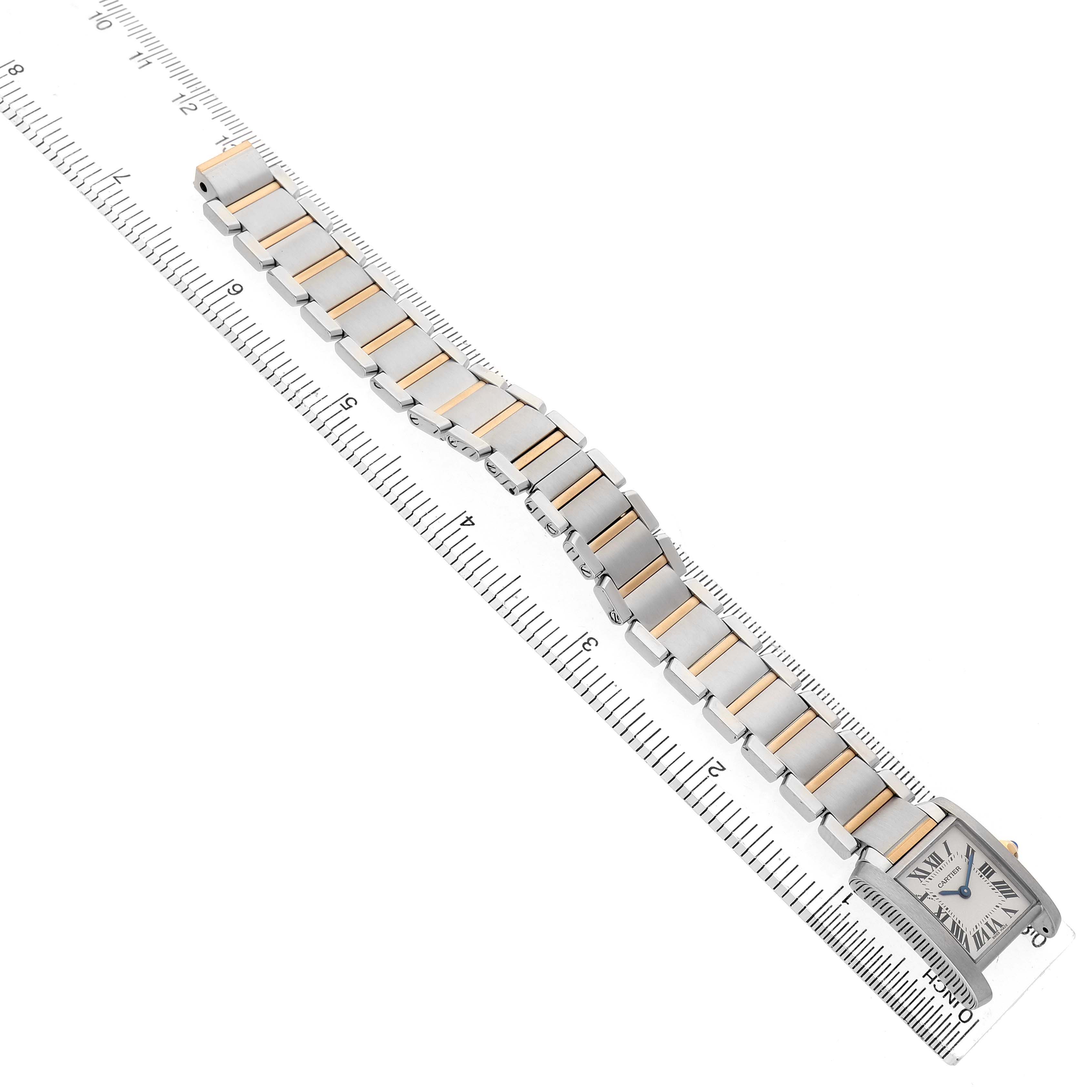 The Tank Française by Cartier is shown from an elevated angle, displaying the watch face, bracelet, and a ruler for scale.