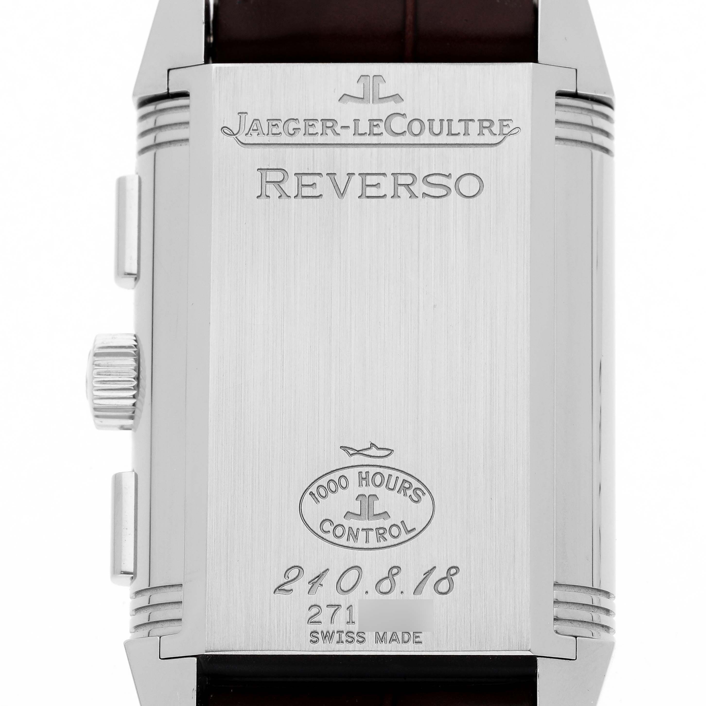 The image shows the back case of a Jaeger-LeCoultre Reverso watch, featuring its engravings and side crown.
