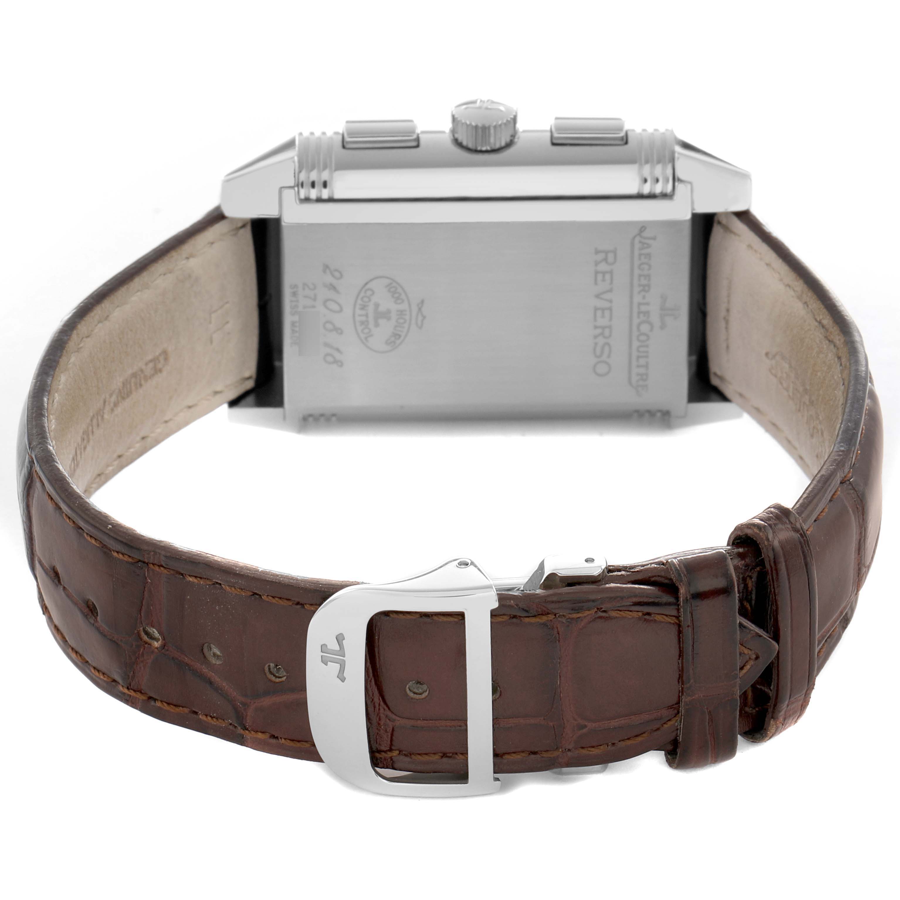 The Jaeger-LeCoultre Reverso watch is shown from the back, highlighting the engraved case and brown leather strap with buckle.