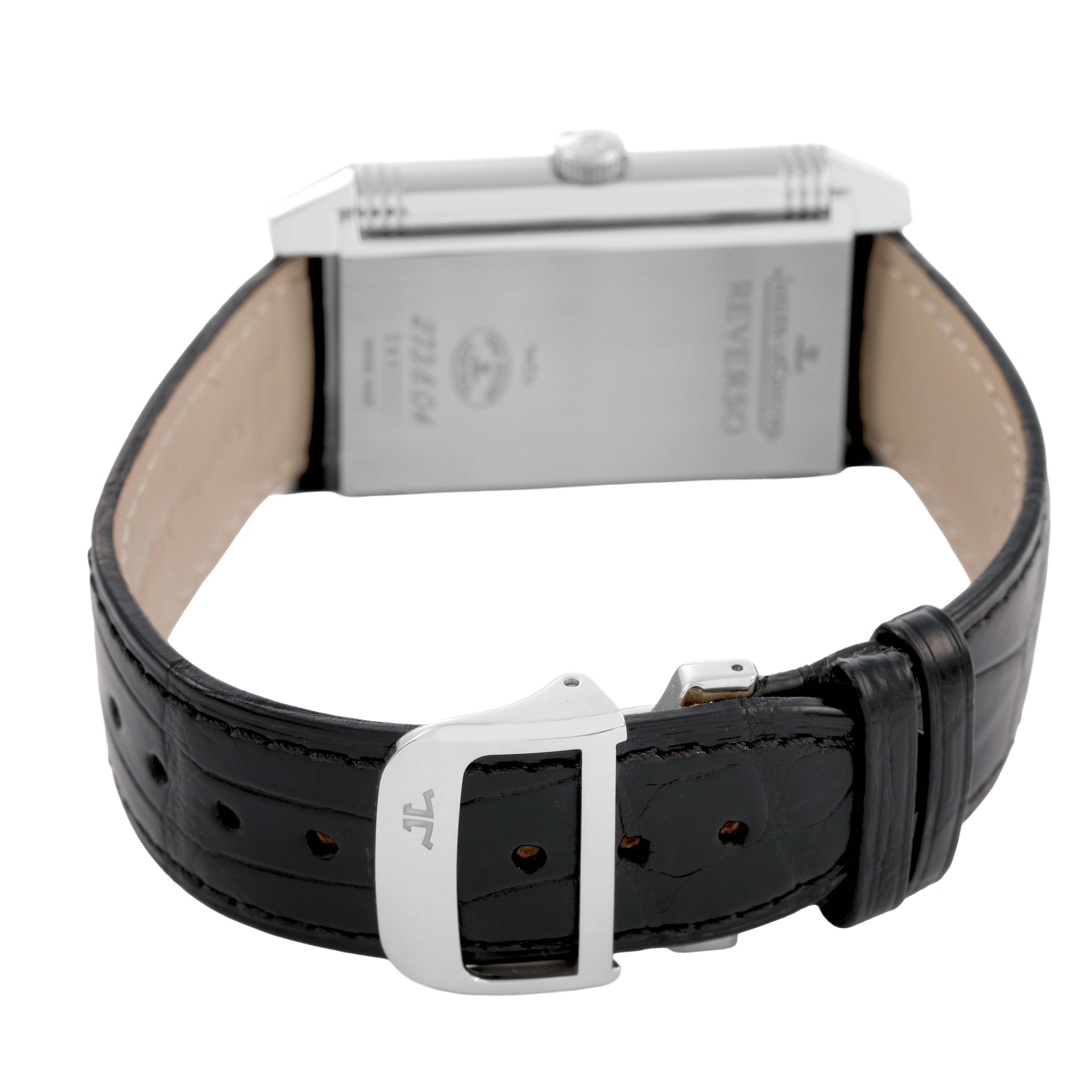 The image shows the Jaeger-LeCoultre Reverso watch from the back, highlighting the clasp, leather strap, and case back details.
