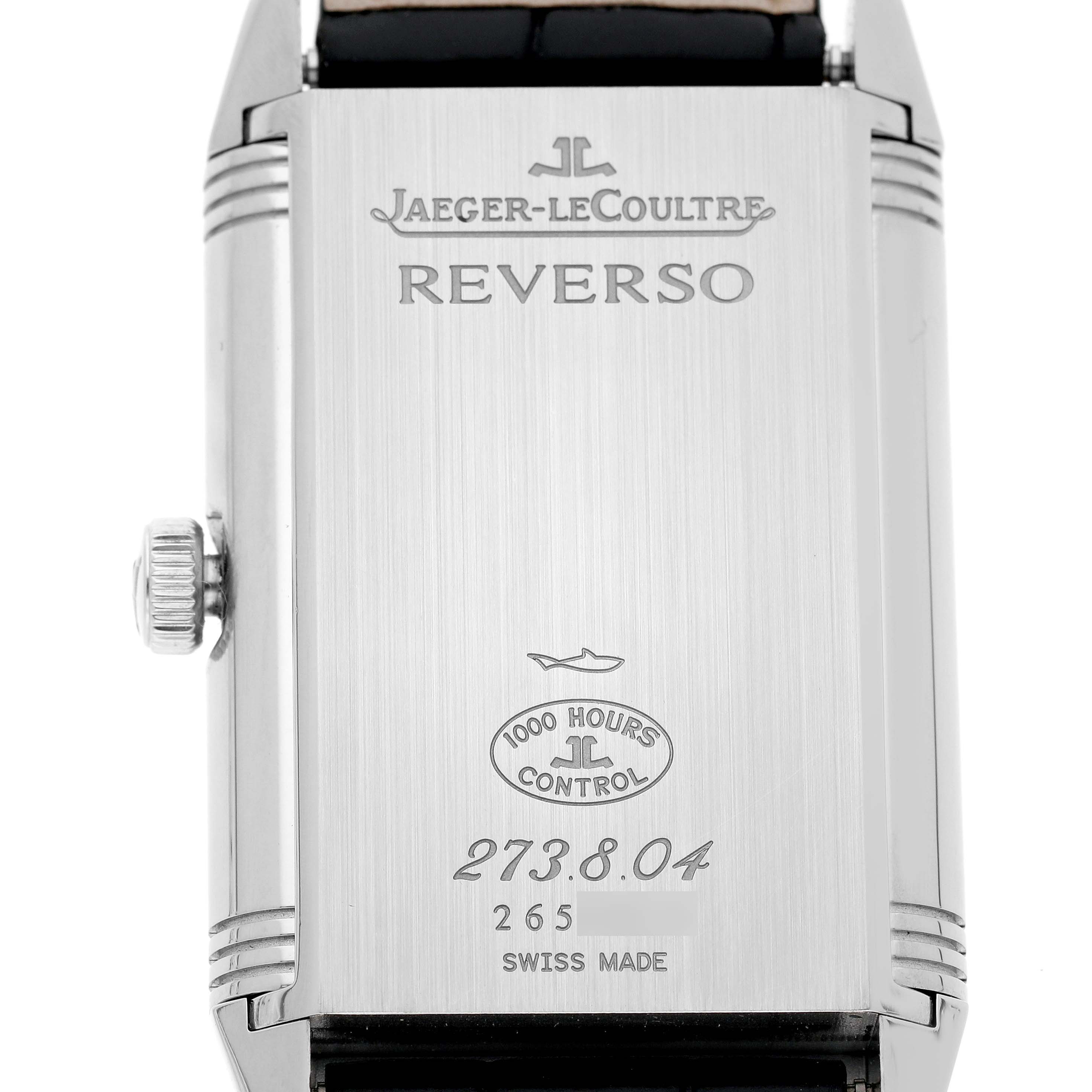The image shows the back of the Jaeger-LeCoultre Reverso watch, highlighting the brand engraving and serial numbers.