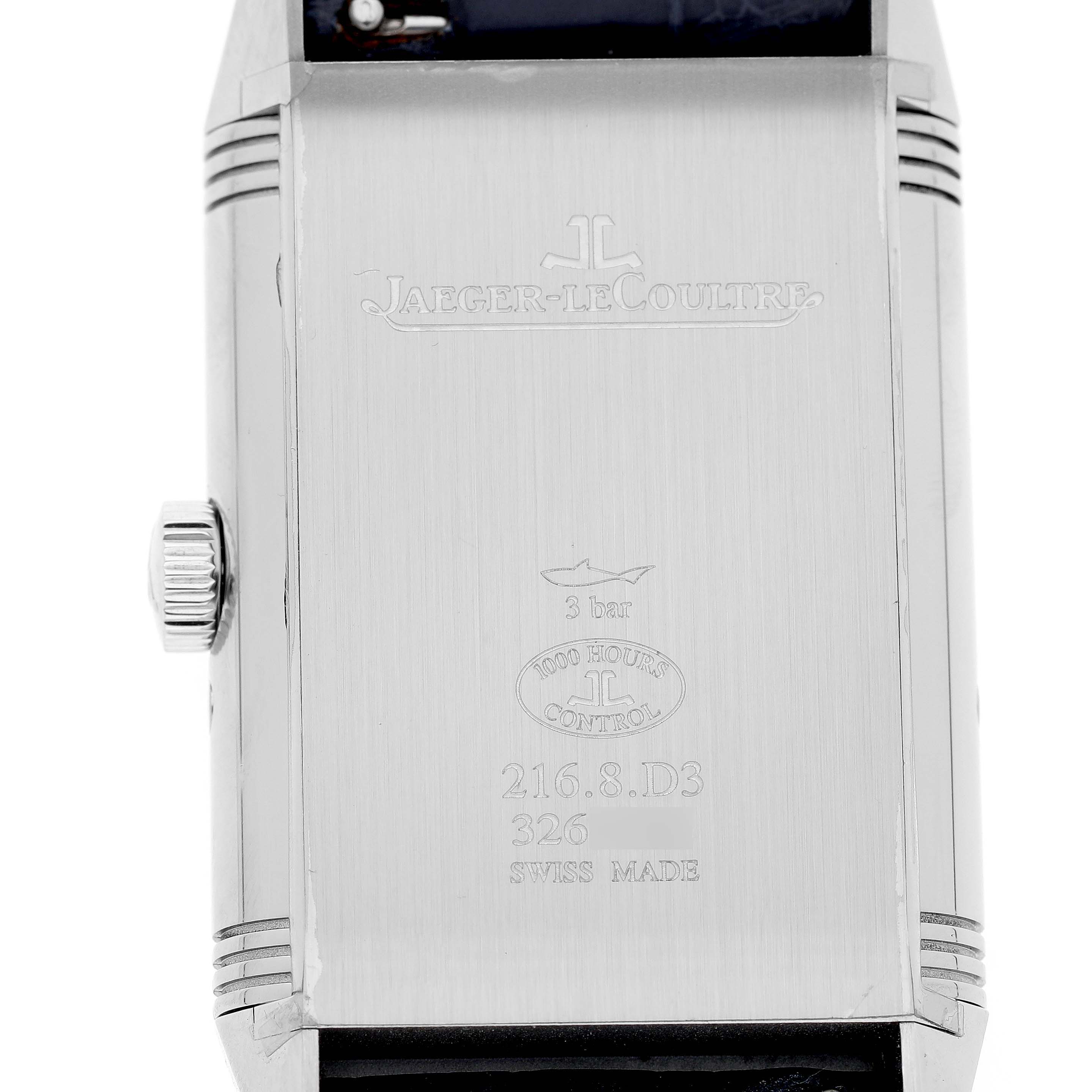 The image shows the back of the Jaeger-LeCoultre Reverso watch, featuring its engravings and crown on the left side.