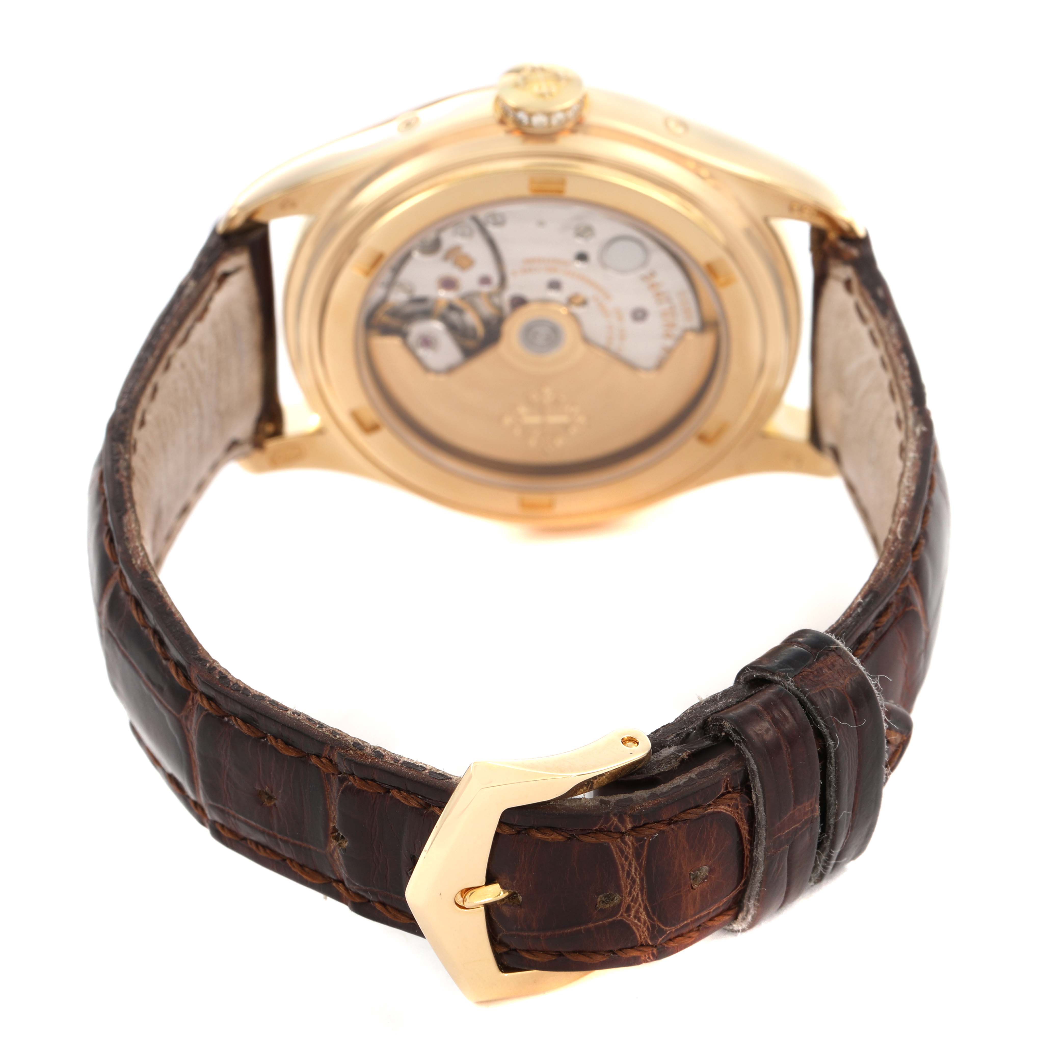 The image shows the back view of a Patek Philippe Complications 4936J Men's Yellow Gold Mother of Pearl Dial watch, highlighting the movement and strap with buckle.