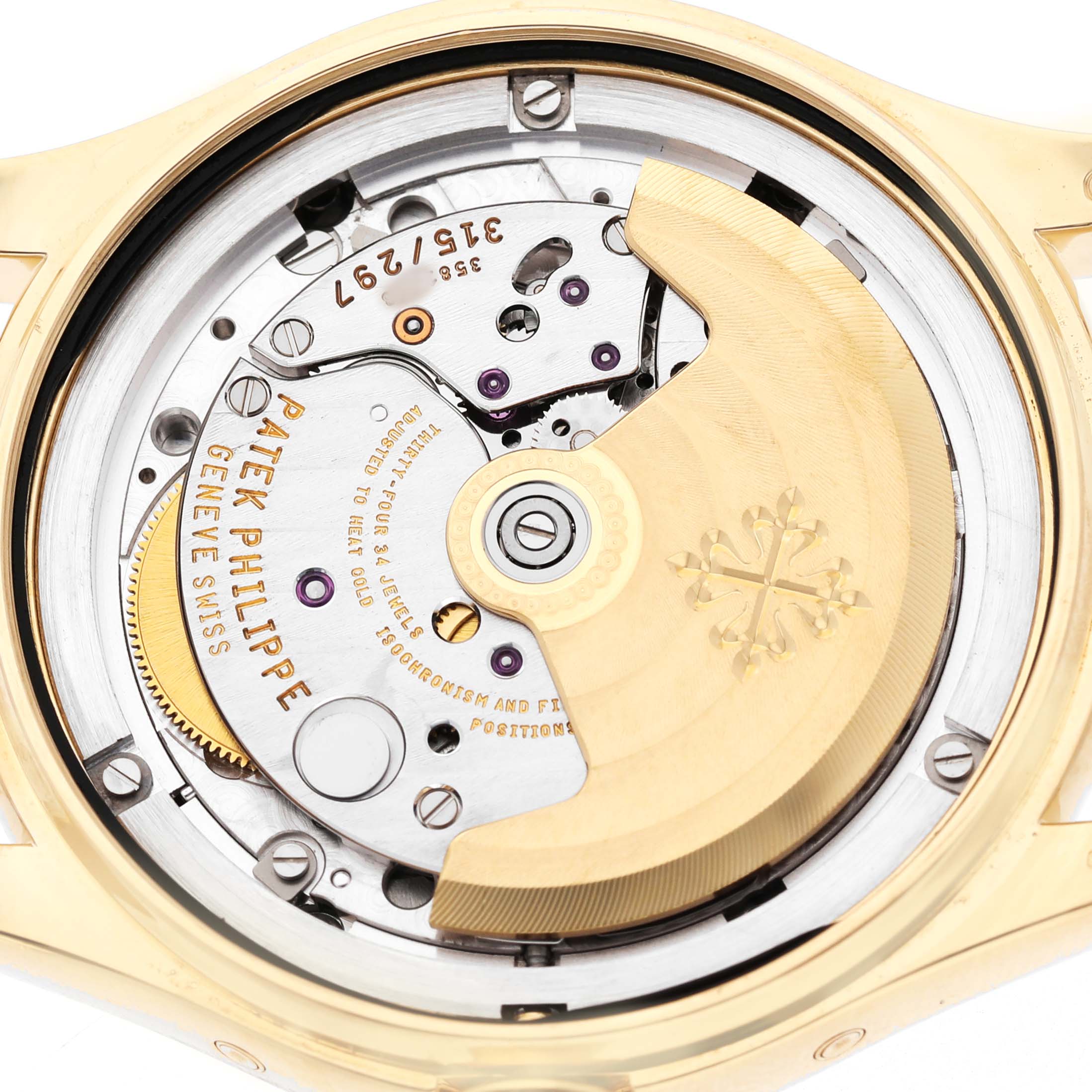The image shows the movement of a Patek Philippe Complications 4936J Men's Yellow Gold Mother of Pearl Dial watch from the back, highlighting the rotor and intricate mechanics.
