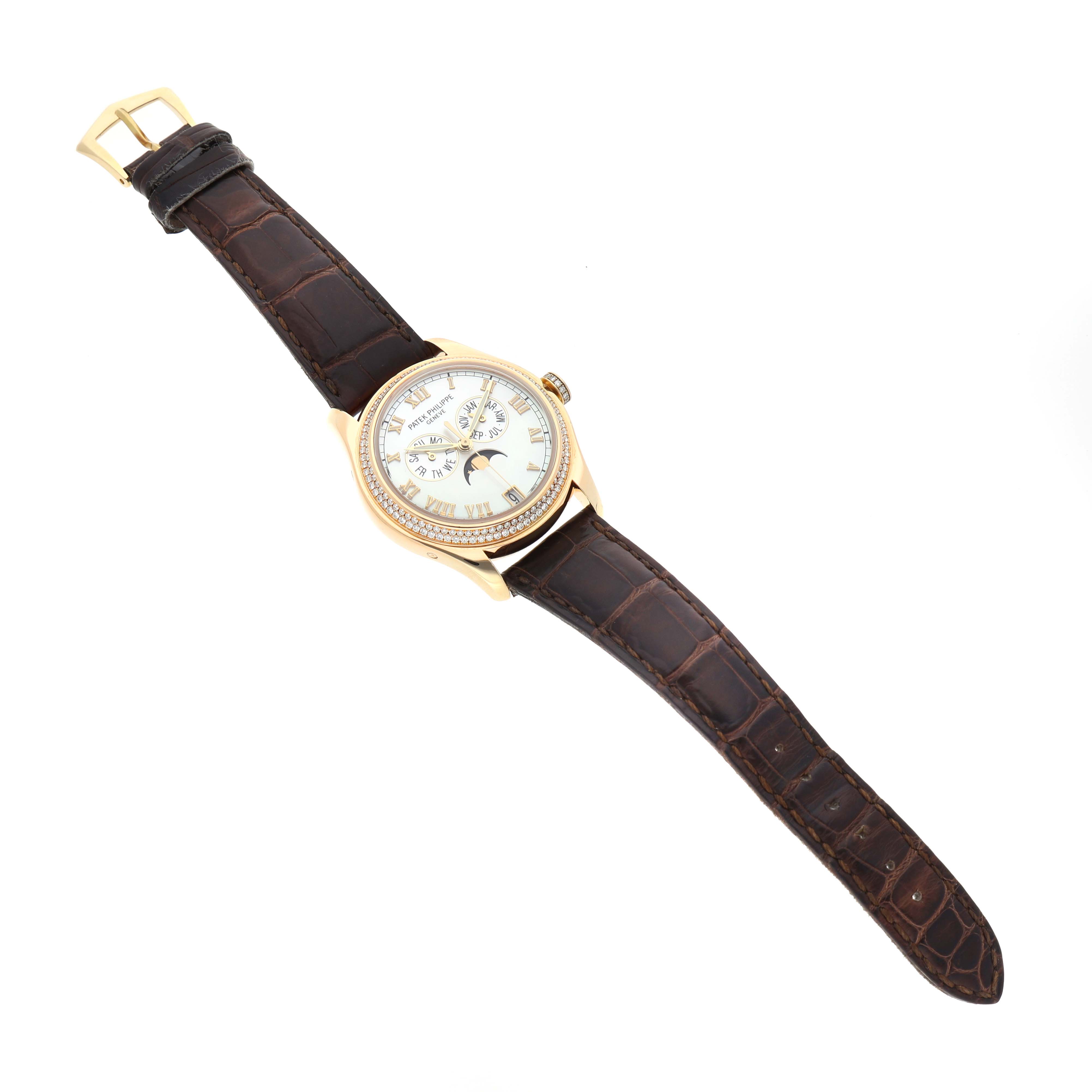 The Patek Philippe Complications 4936J Men's Yellow Gold Mother of Pearl Dial watch is shown from a top-down angle, displaying the entire face, case, and leather strap.