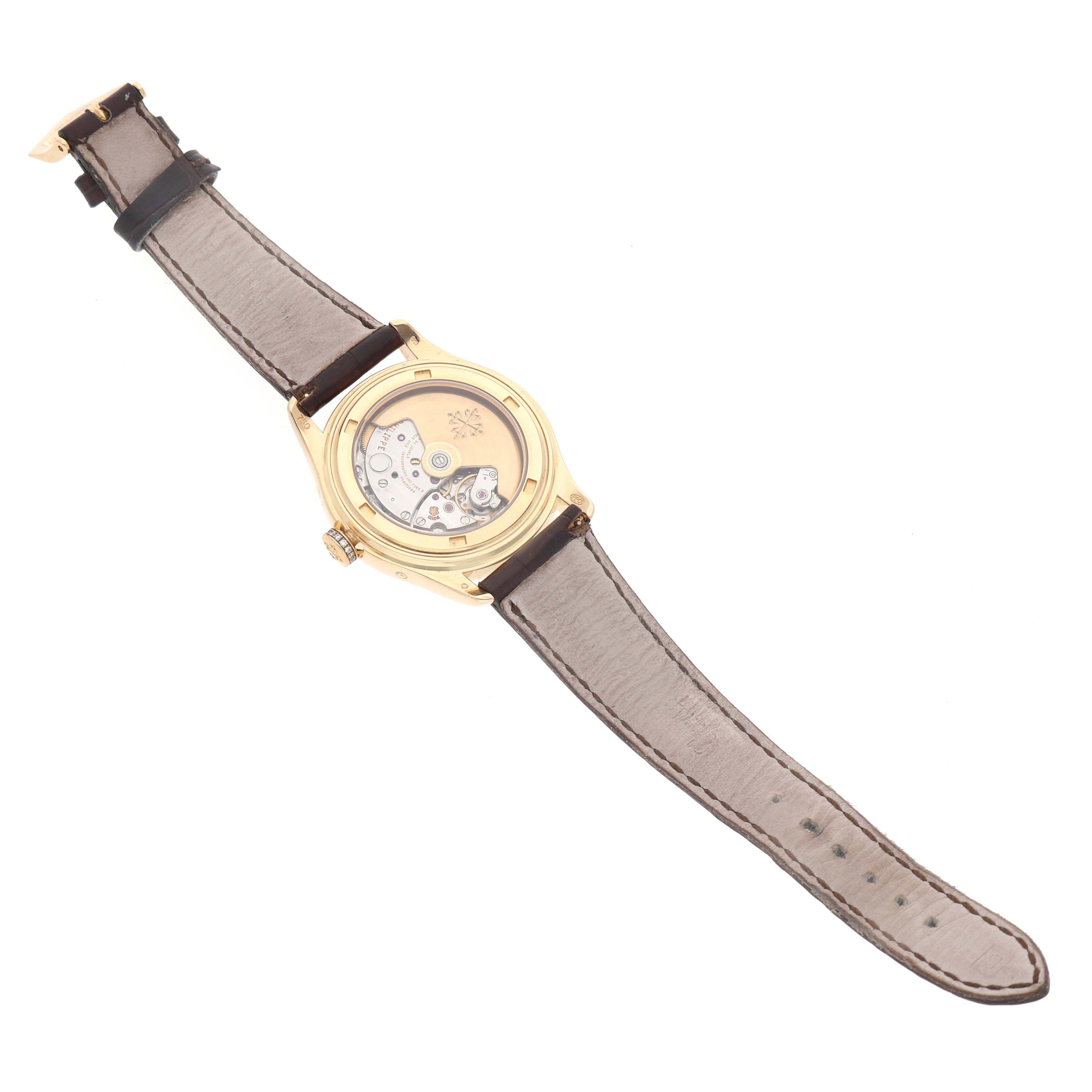 The Patek Philippe Complications 4936J Men's Yellow Gold Mother of Pearl Dial watch is shown from the back, displaying the movement and leather strap.