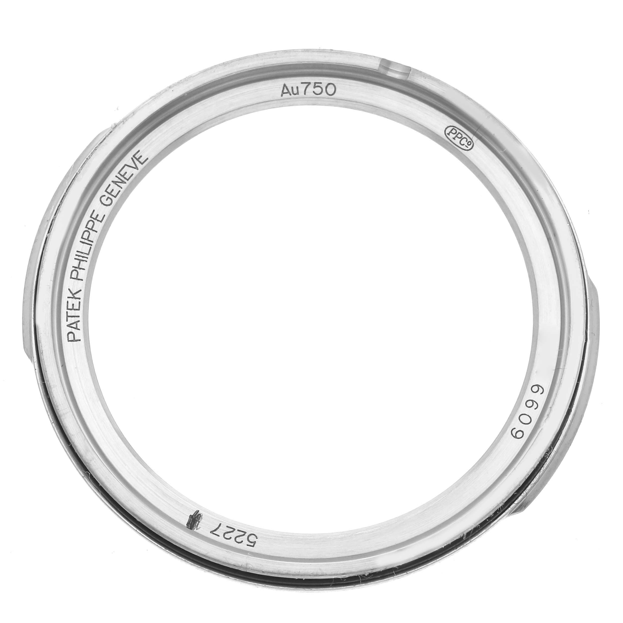 The image shows a top view of the Patek Philippe Calatrava 5227G Men
s White Gold Black Dial watch
s case back, featuring engravings and hallmarks.