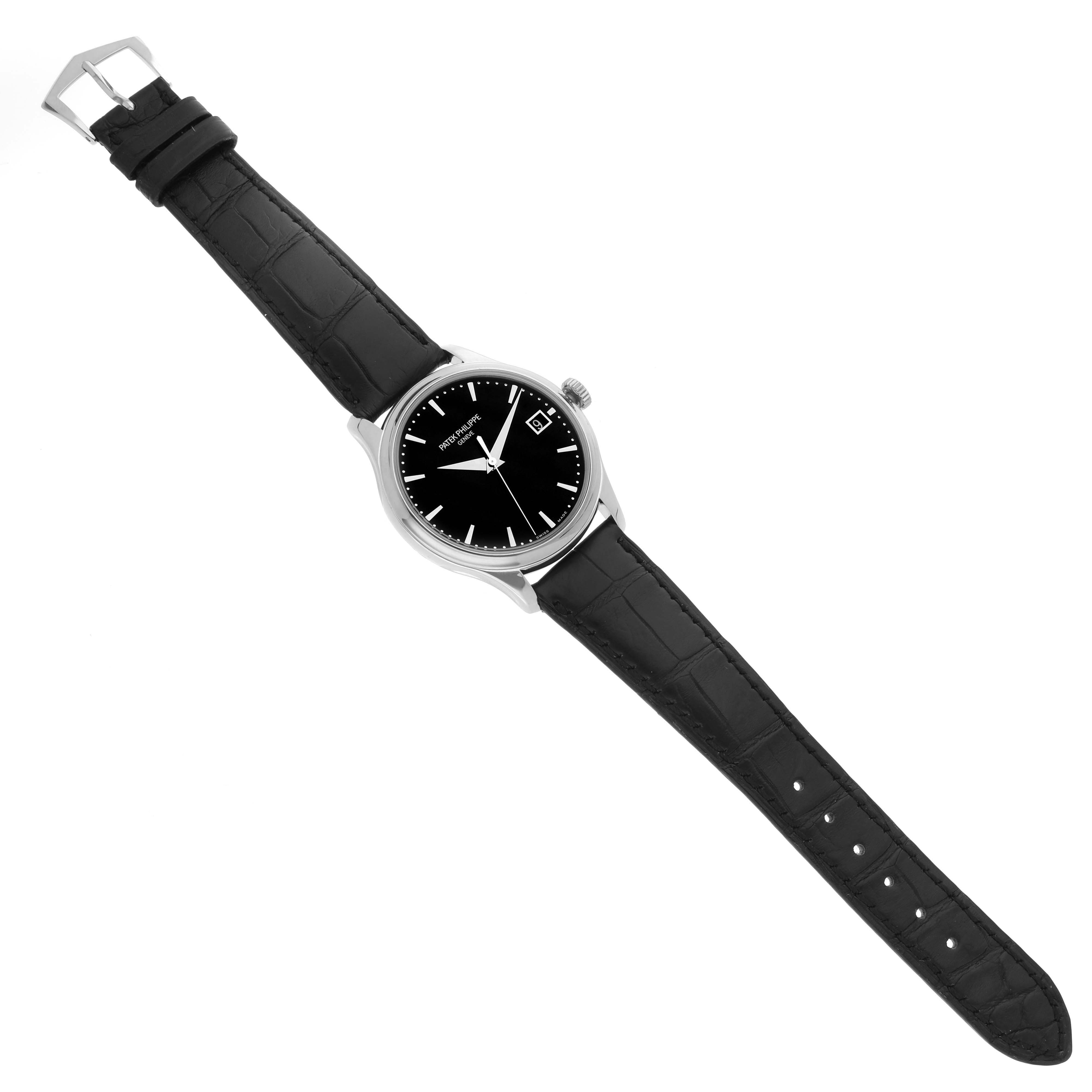 The Patek Philippe Calatrava 5227G Men
s White Gold Black Dial watch is shown from a top-down angle, highlighting its black dial, strap, and buckle.