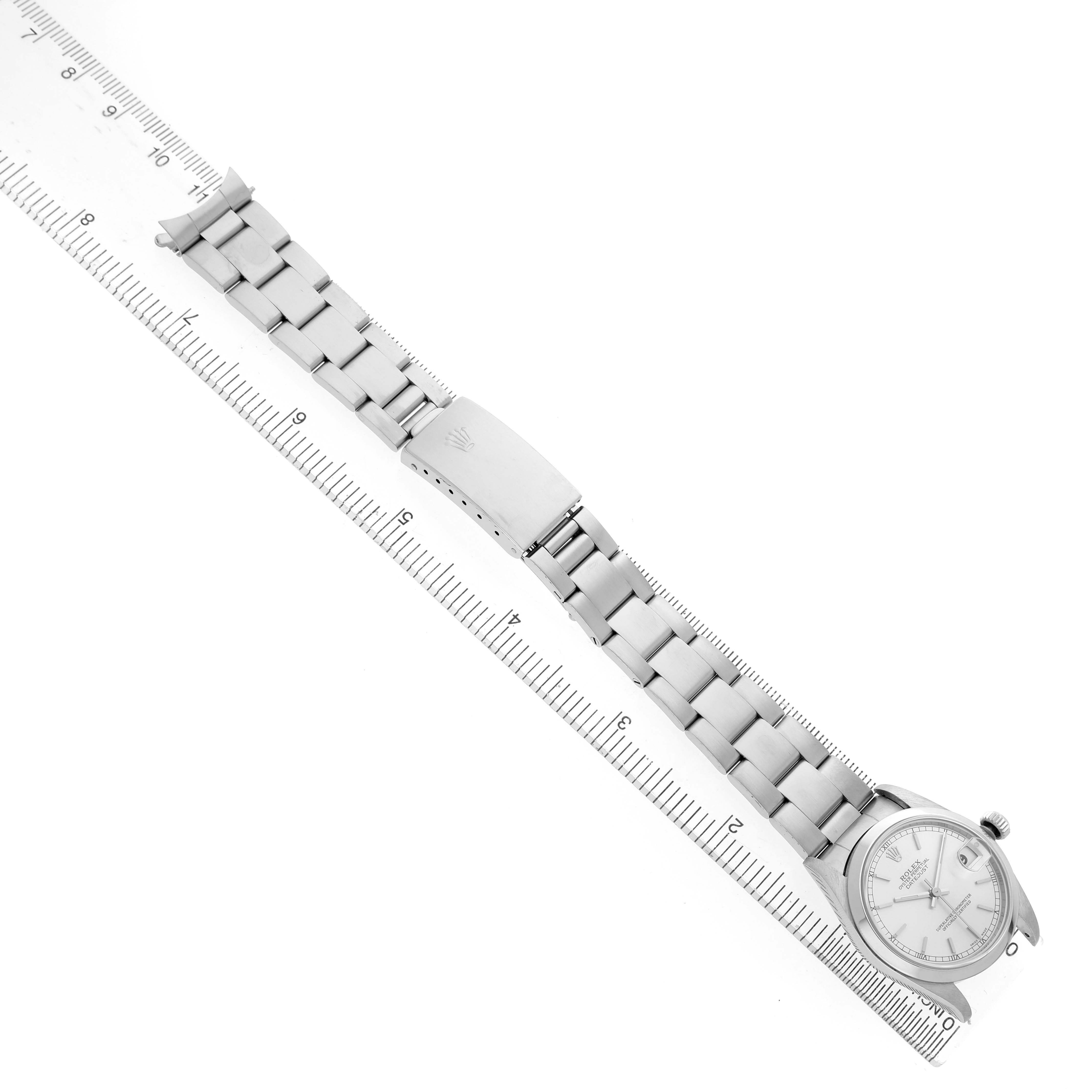 The image shows a Rolex Mid-Size 78240 Women's Stainless Steel Silver Dial watch laid flat with its face, band, and clasp visible, aligned next to a ruler.