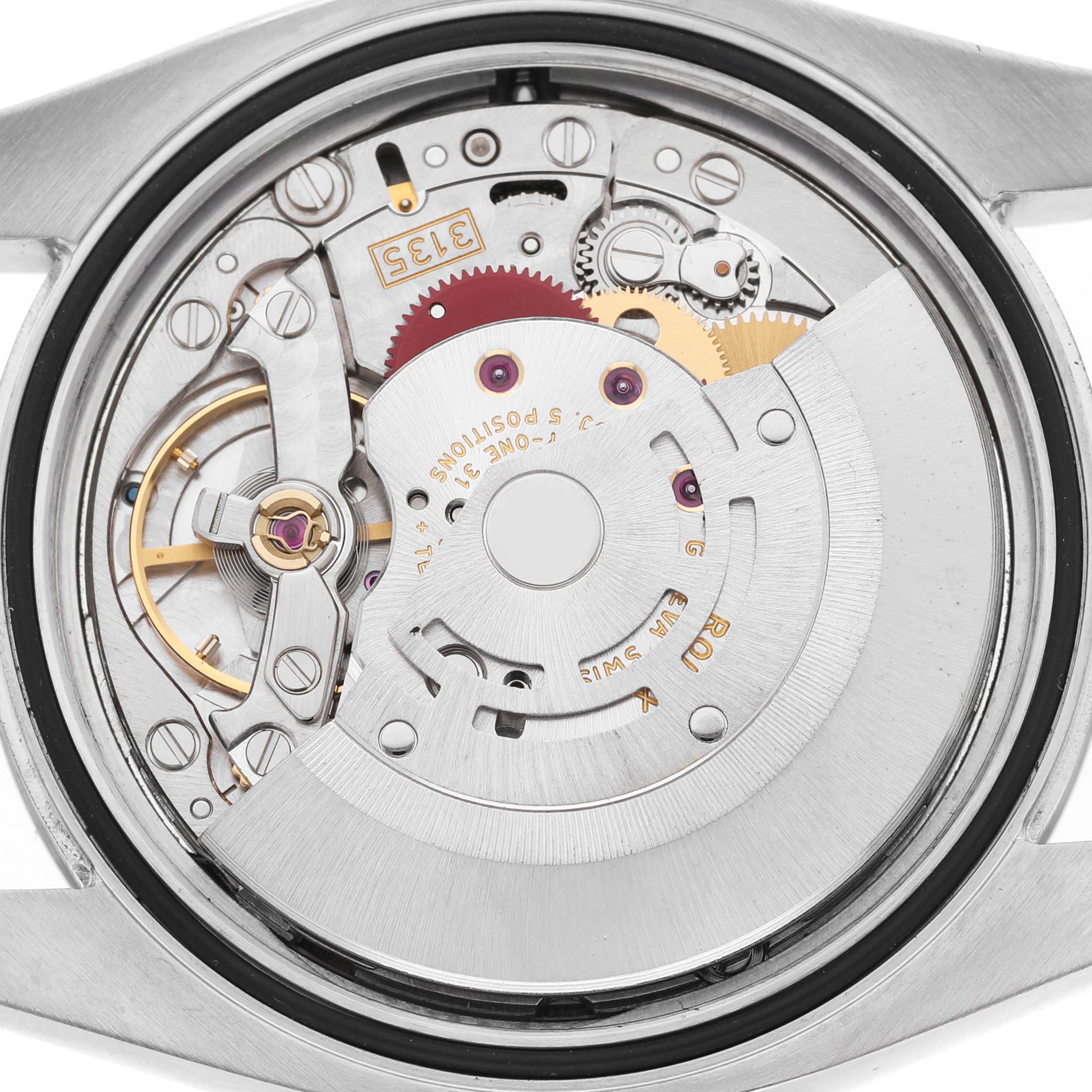 The image shows the movement of a Rolex Datejust 116234 Men's Stainless Steel Mother of Pearl Dial watch from a rear angle, highlighting its intricate gears and rotor.