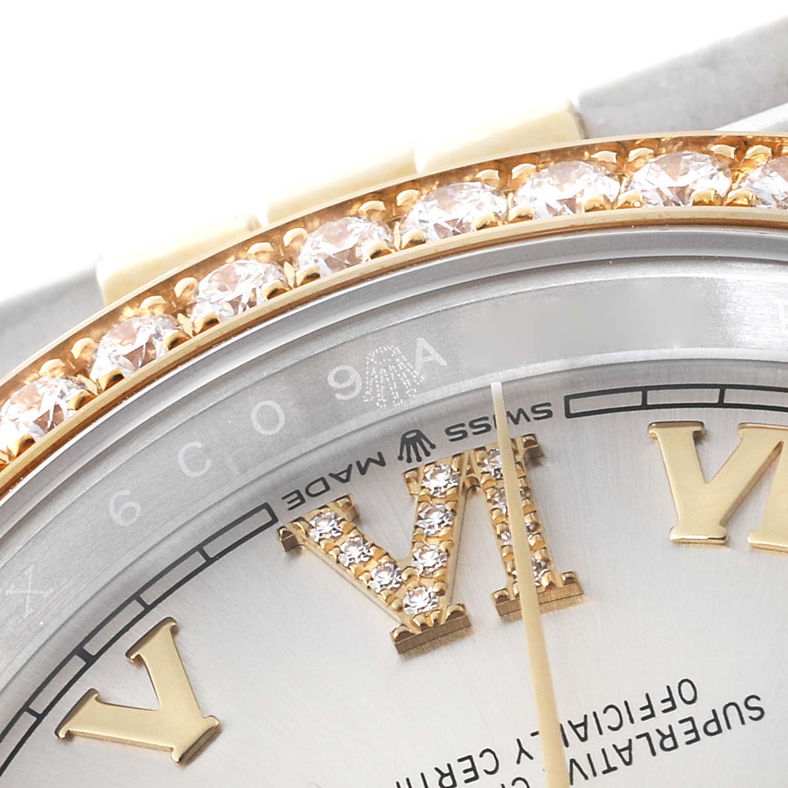 This close-up angle of the Rolex Datejust 126283 Men's Steel and Gold (two tone) Silver Dial 126283 Men's Steel and Gold (two tone) Silver Dial watch focuses on its diamond-studded Roman numeral "VI" and bezel.