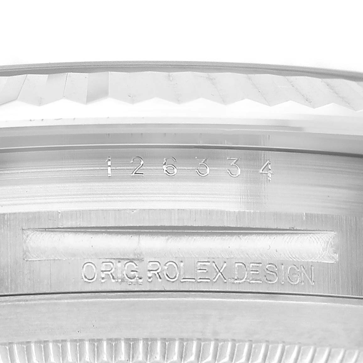 The image shows a close-up of the Rolex Datejust 41 126334 Men's Stainless Steel Green Dial's case edge, featuring engravings and the fluted bezel.