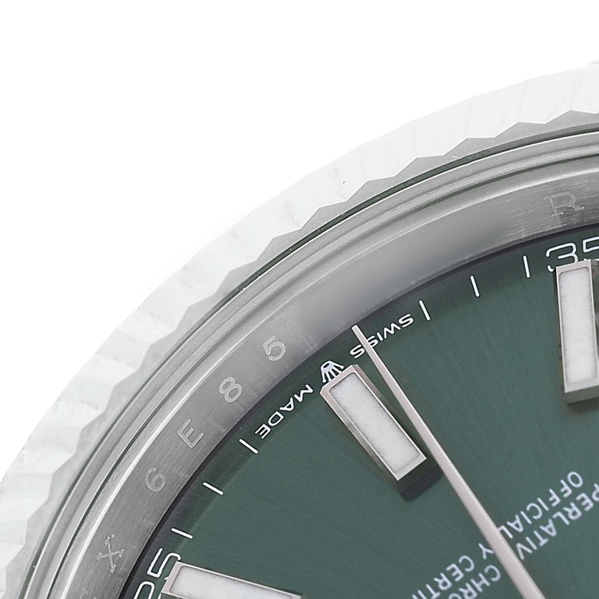 The image shows a close-up of the dial and fluted bezel of a Rolex Datejust 41 126334 Men's Stainless Steel Green Dial, focusing on the indices and textured edge.