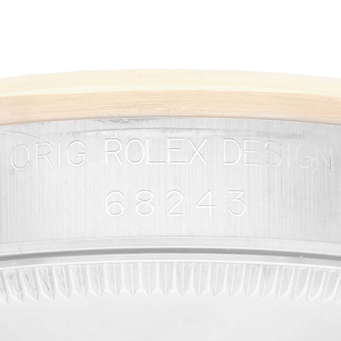 The image shows a close-up of the side of a Rolex Datejust 68243 Women
s Steel and Gold (two tone) White Dial watch, highlighting the model number and "ORIG ROLEX DESIGN" engraving.