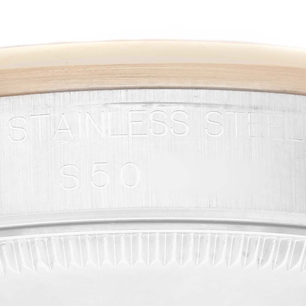 The image shows a close-up of the bezel and casing edge of a Rolex Datejust 68243 Women
s Steel and Gold (two tone) White Dial watch, highlighting its stainless steel composition.