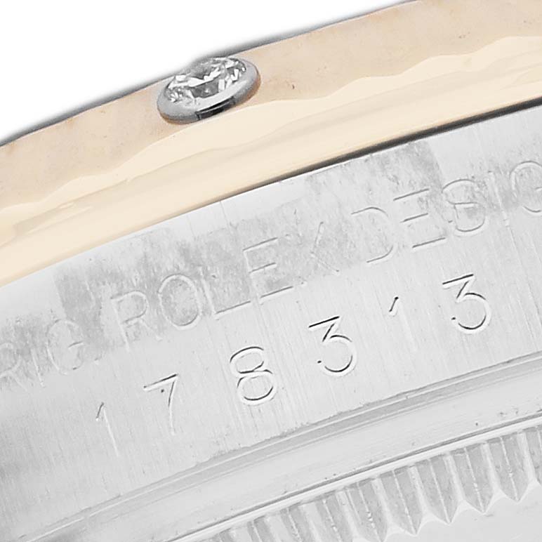 The image shows an angled close-up of the case back edge of a Rolex Datejust 178313 Men
s Steel and Gold (two tone) Mother of Pearl Dial, with visible screw and engraving details.