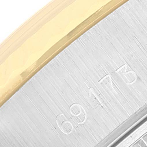 The image shows a close-up of the side of a Rolex Datejust 69173 Women's Steel and Gold (two tone) Silver Dial 69173 Women's Steel and Gold (two tone) Silver Dial watch, focusing on the engraved serial number and the two-tone bezel.
