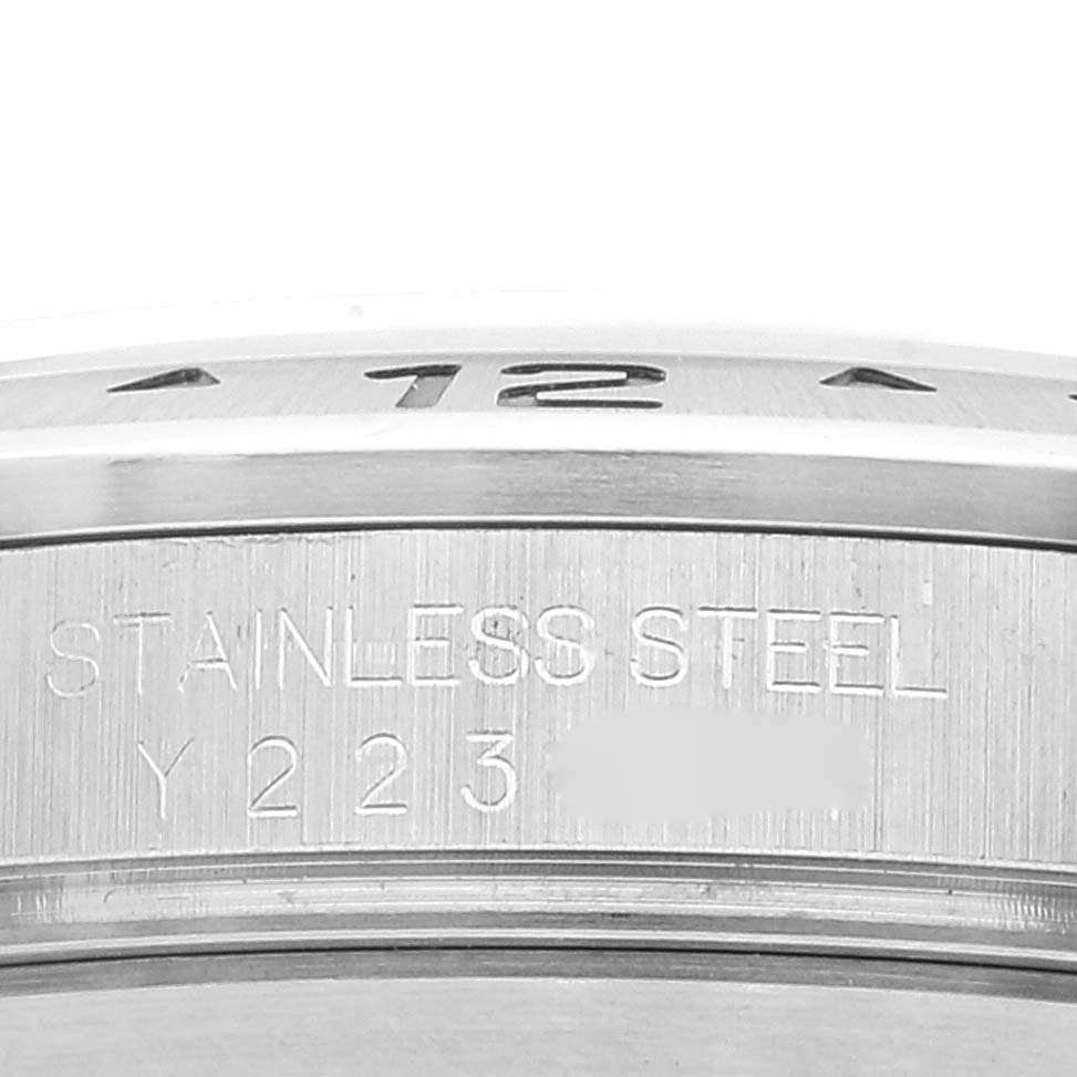 The image shows a close-up of the stainless steel bezel and part of the casing with an engraving on the Rolex Explorer 16570 Men
s Stainless Steel White Dial 16570 Men
s Stainless Steel White Dial model watch.